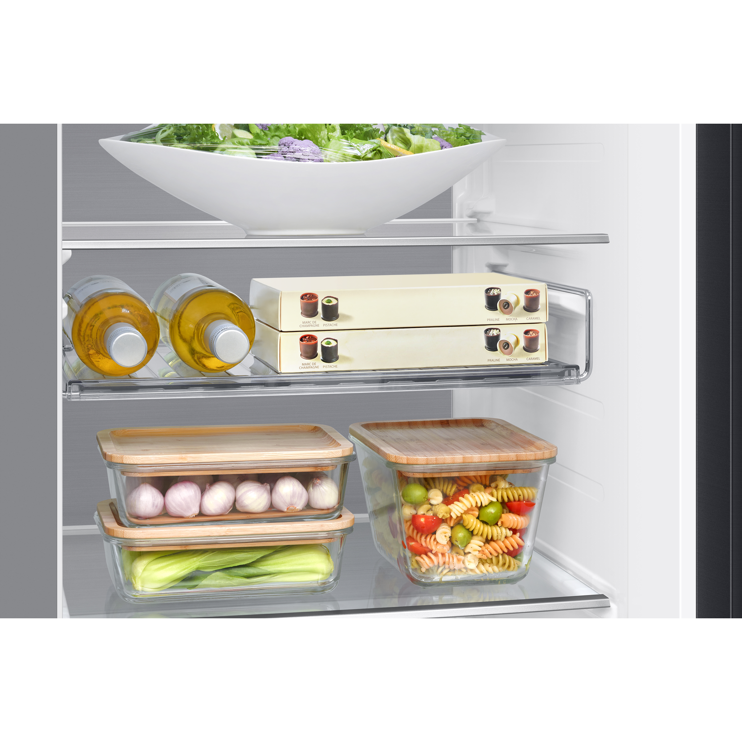 Koelkast interieur met eten. Twee flessen olie. Glazen containers met eten.
