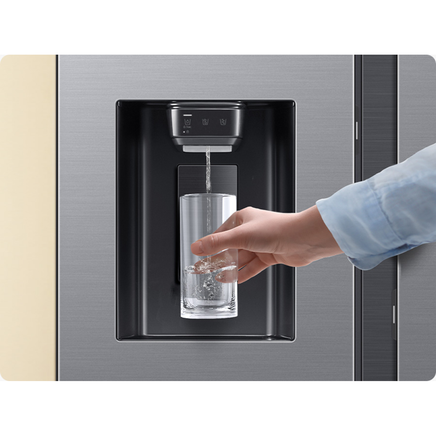 Een hand die een glas vult met water uit de waterdispenser van een koelkast, met een beige frame.