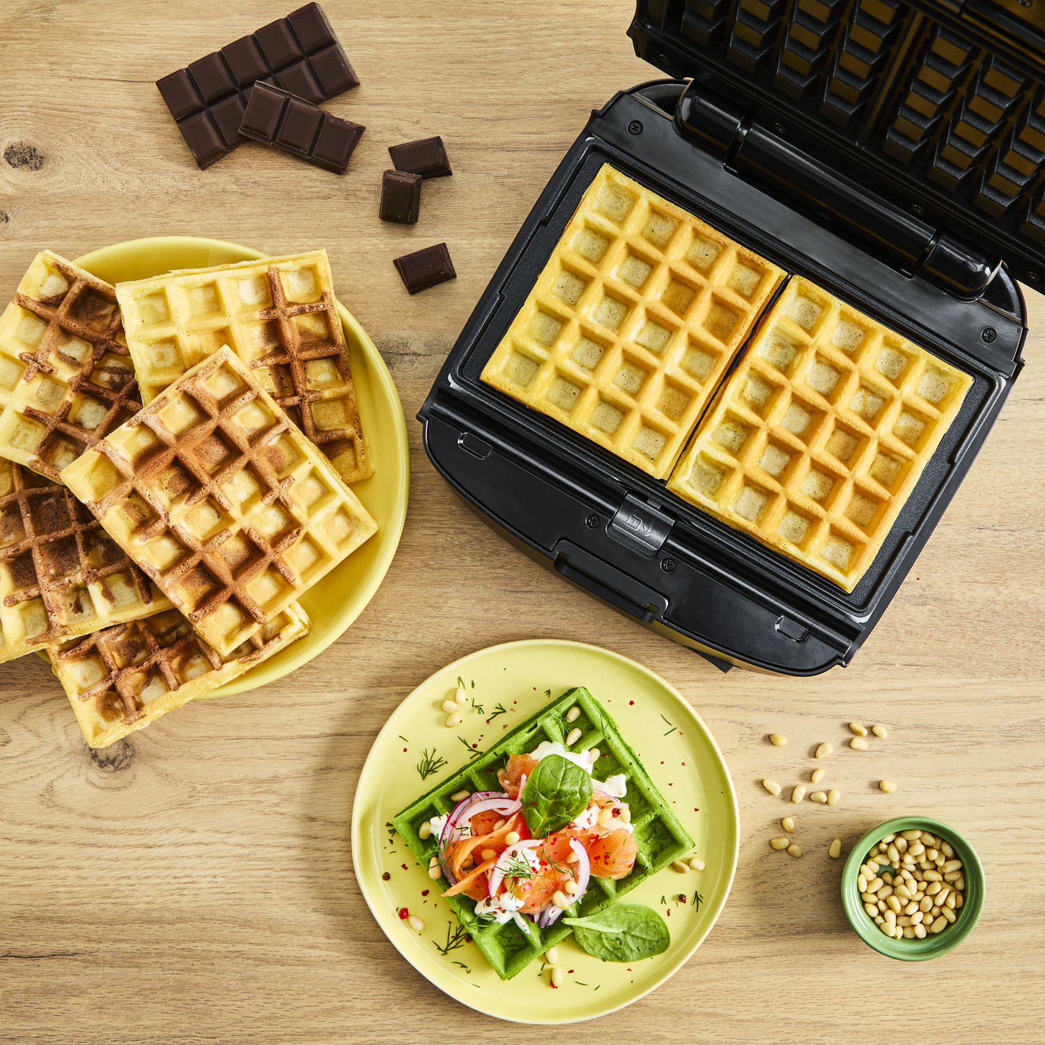 Top view of a waffle maker, waffles and chocolate.