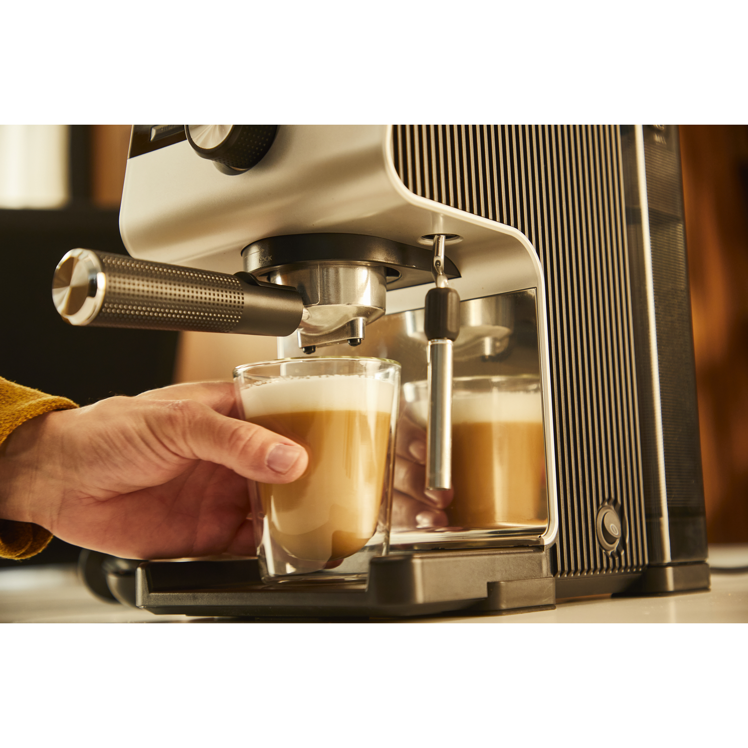 Persoon maakt koffie met een koffiezetapparaat.