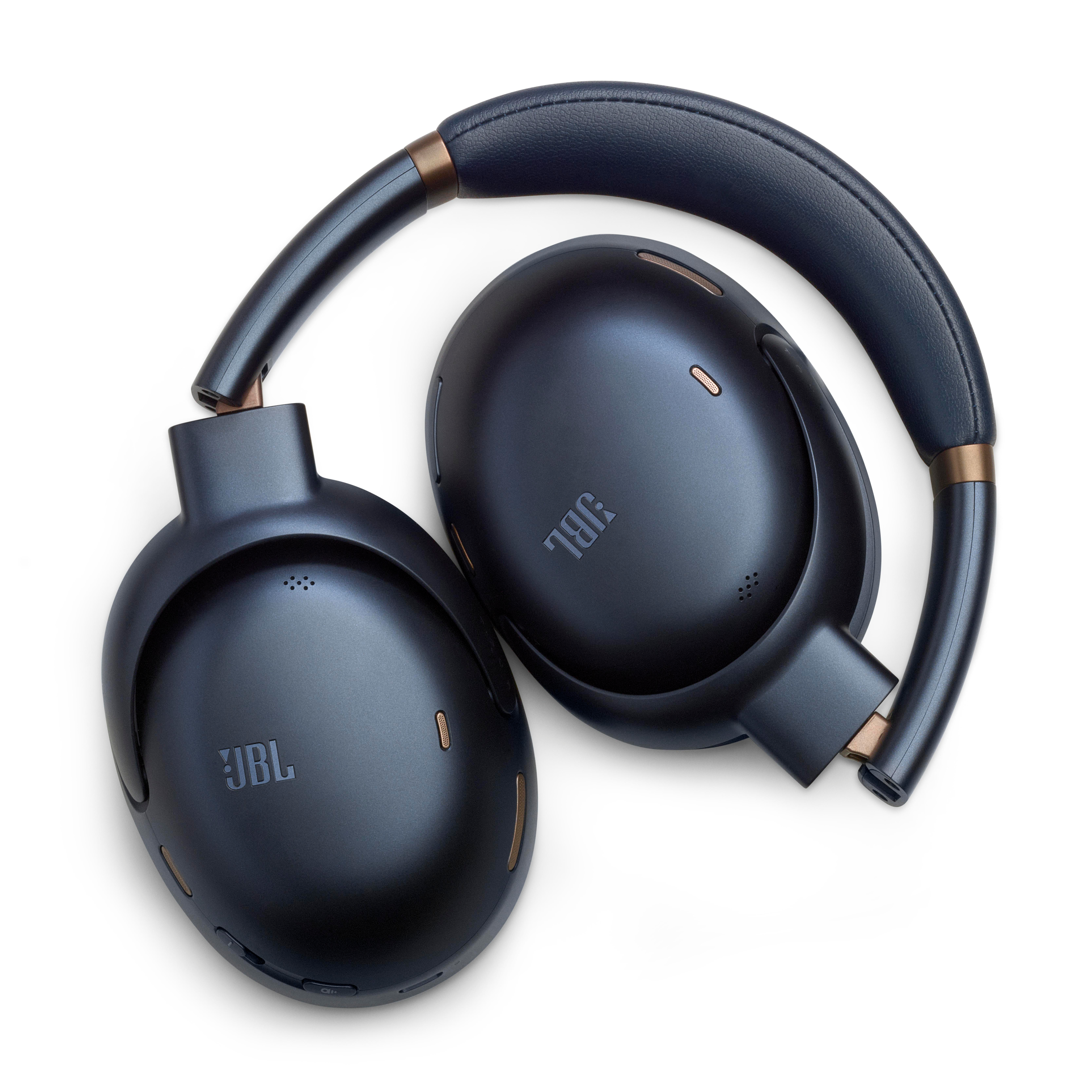 Gefaltete marineblaue kabellose Kopfhörer mit JBL-Logo, auf weißer Oberfläche liegend.