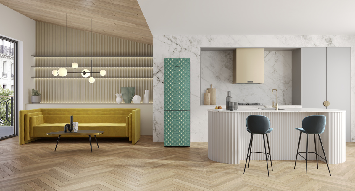 Modernes Kücheninterieur mit einem grün gemusterten Kühlschrank und einem gelben Sofa.