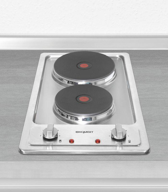 Zwei schwarze Herdplatten auf Edelstahl-Oberfläche.