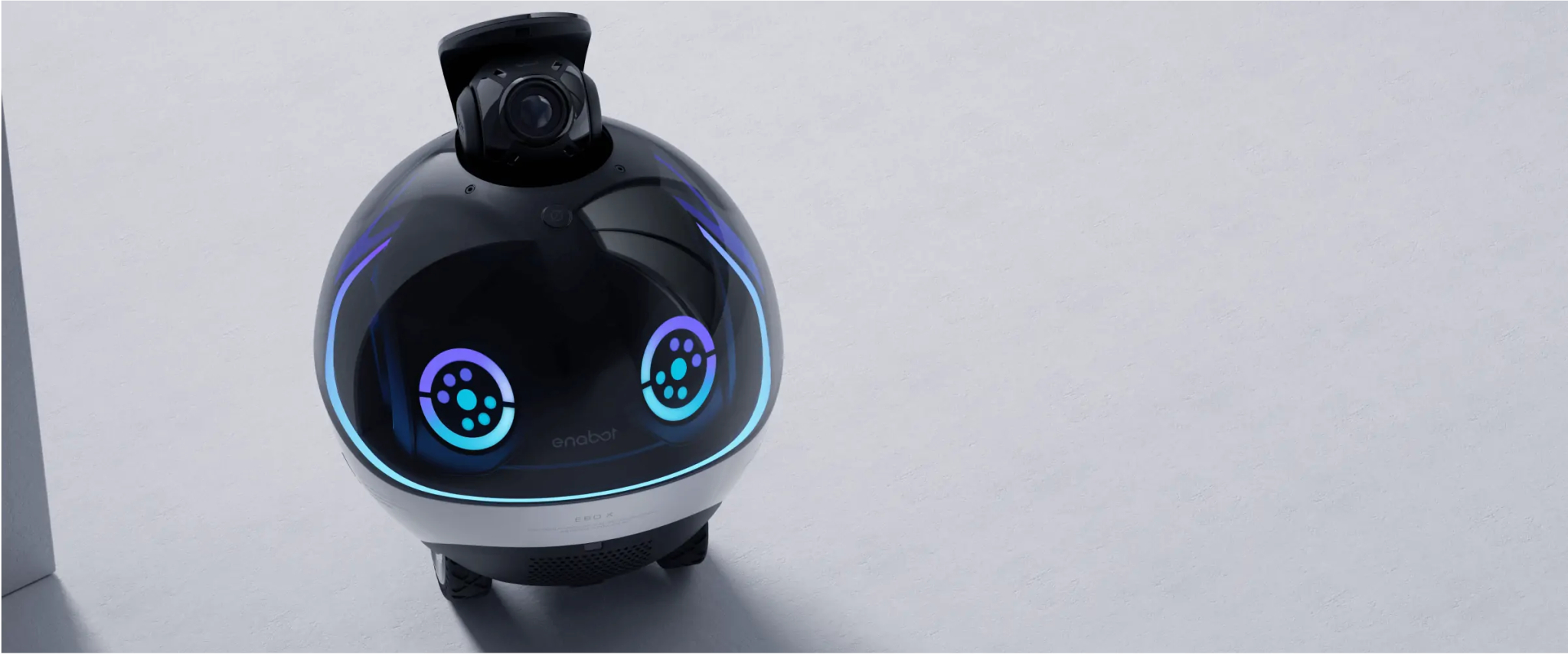 Robot z kamerą na górze, okrągłym korpusem i niebiesko-fioletowymi światłami.