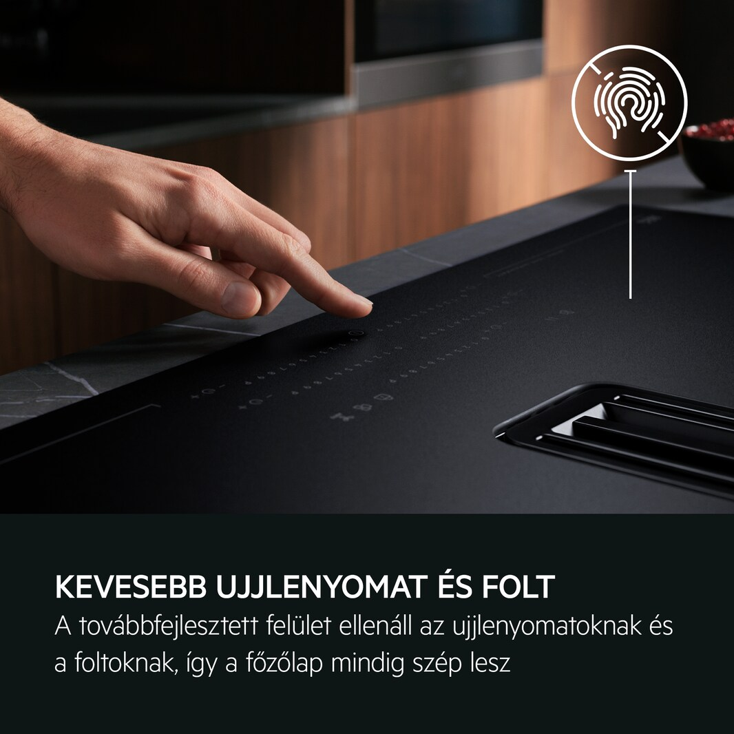 Ujj érint egy fekete főzőlapot. A szöveg kevesebb ujjlenyomatot és foltot jelez. Fehér ujjlenyomat ikon.