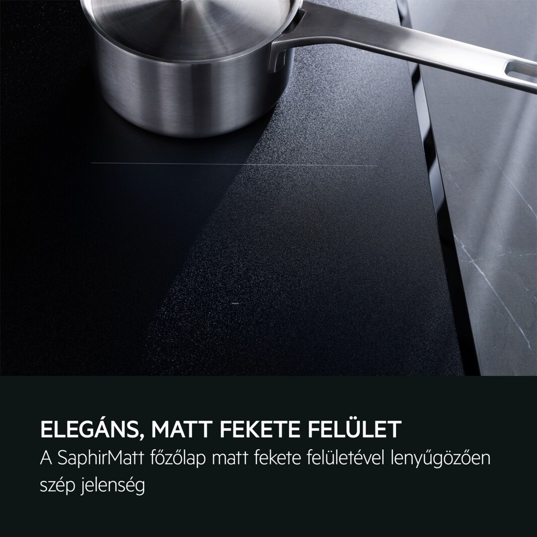 Fekete főzőlap felület ezüst edénnyel. Szöveg: 'Elegáns, matt fekete felület'. Közelkép.