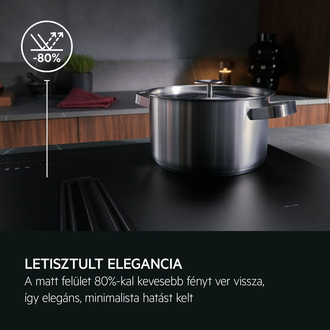 Rozsdamentes acél edény fekete tűzhelyen, eleganciáról és fényvisszaverődésről szóló szöveggel.