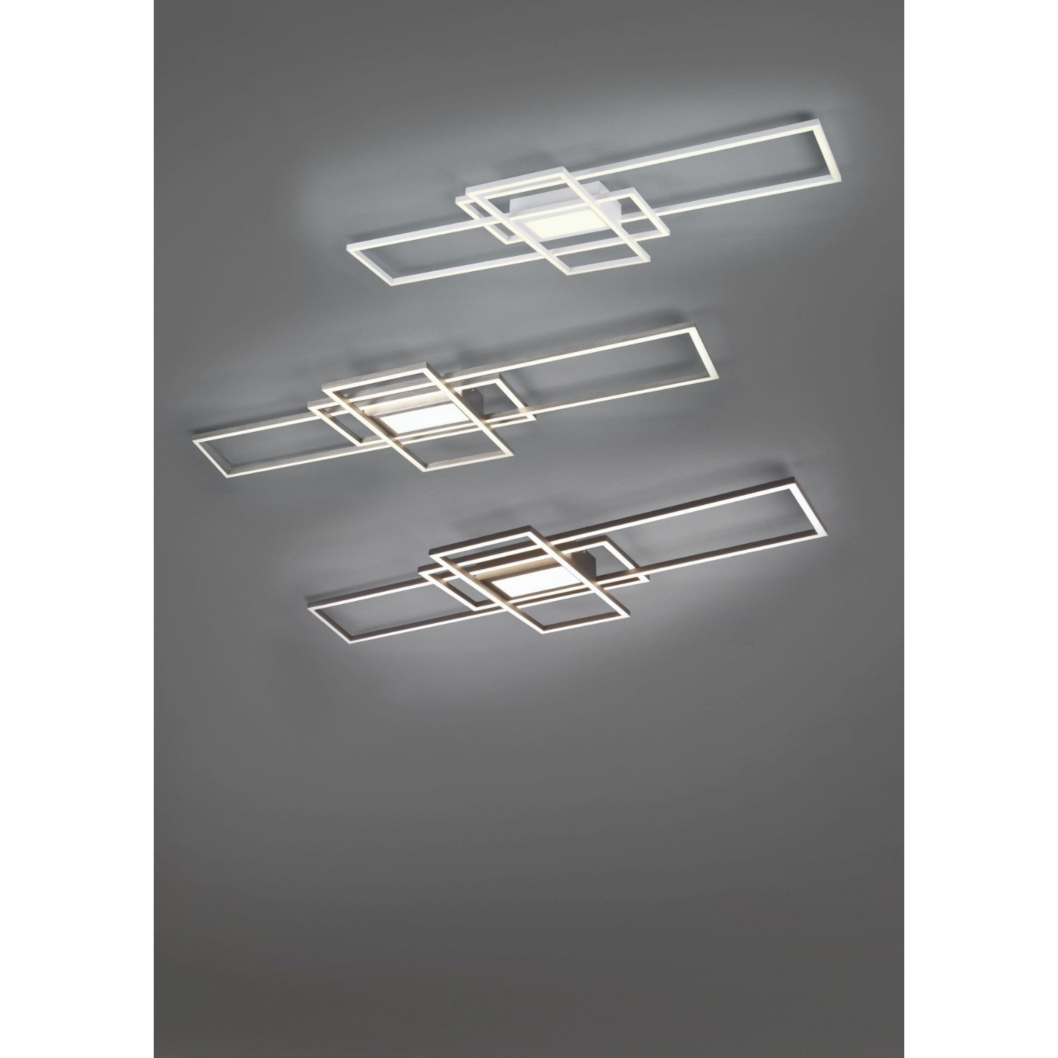 Tre luci a soffitto con forme geometriche bianche.