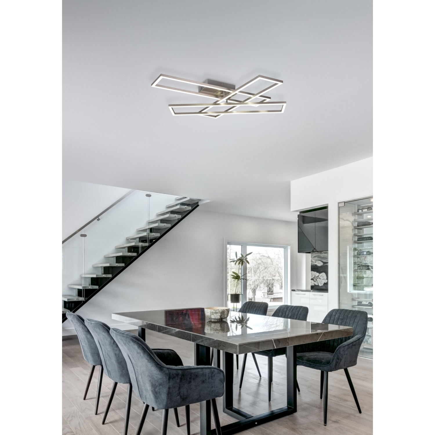 Sala da pranzo con tavolo, sedie e lampada a soffitto.