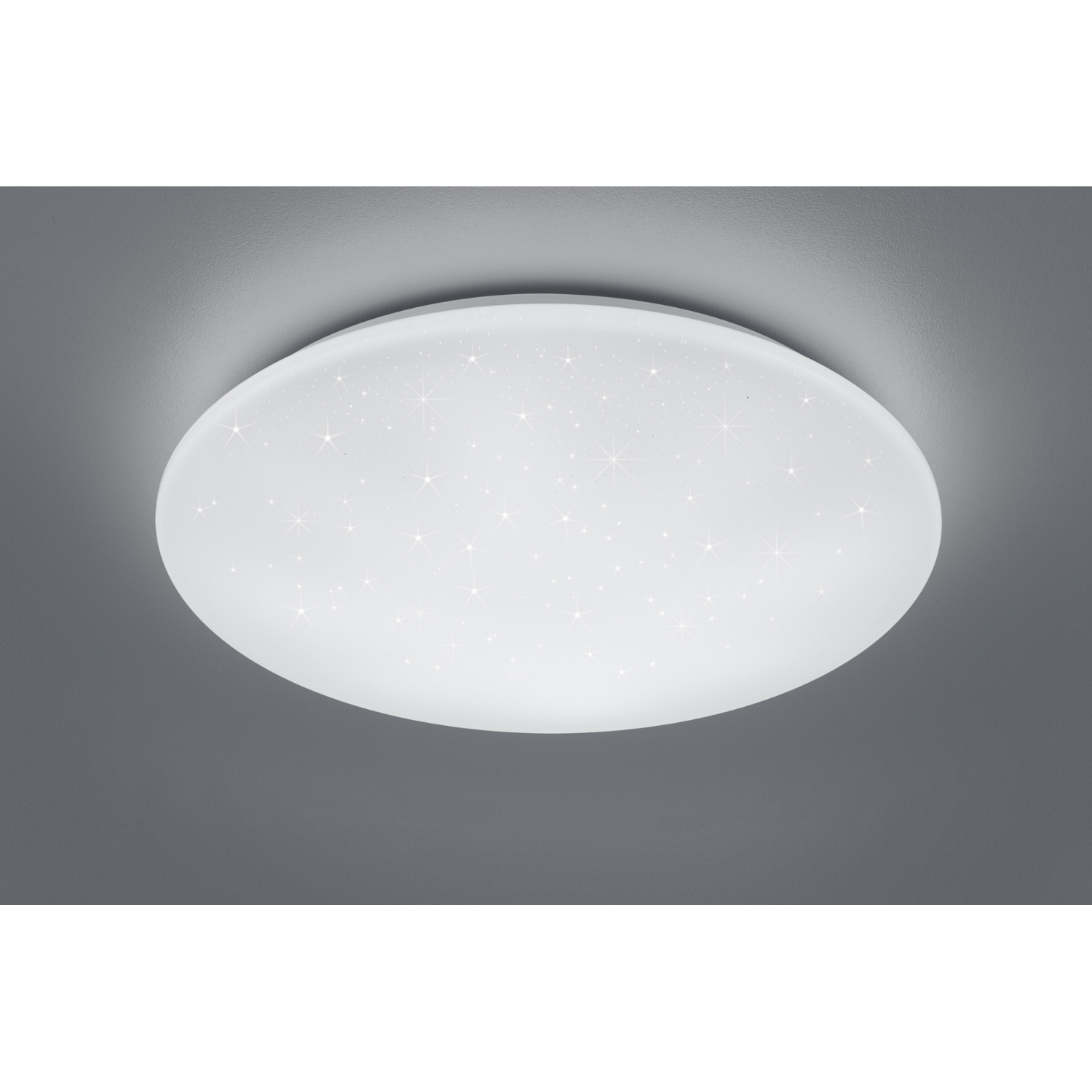 Lampada da soffitto bianca. La lampada è rotonda e ha delle stelle. Sfondo grigio.