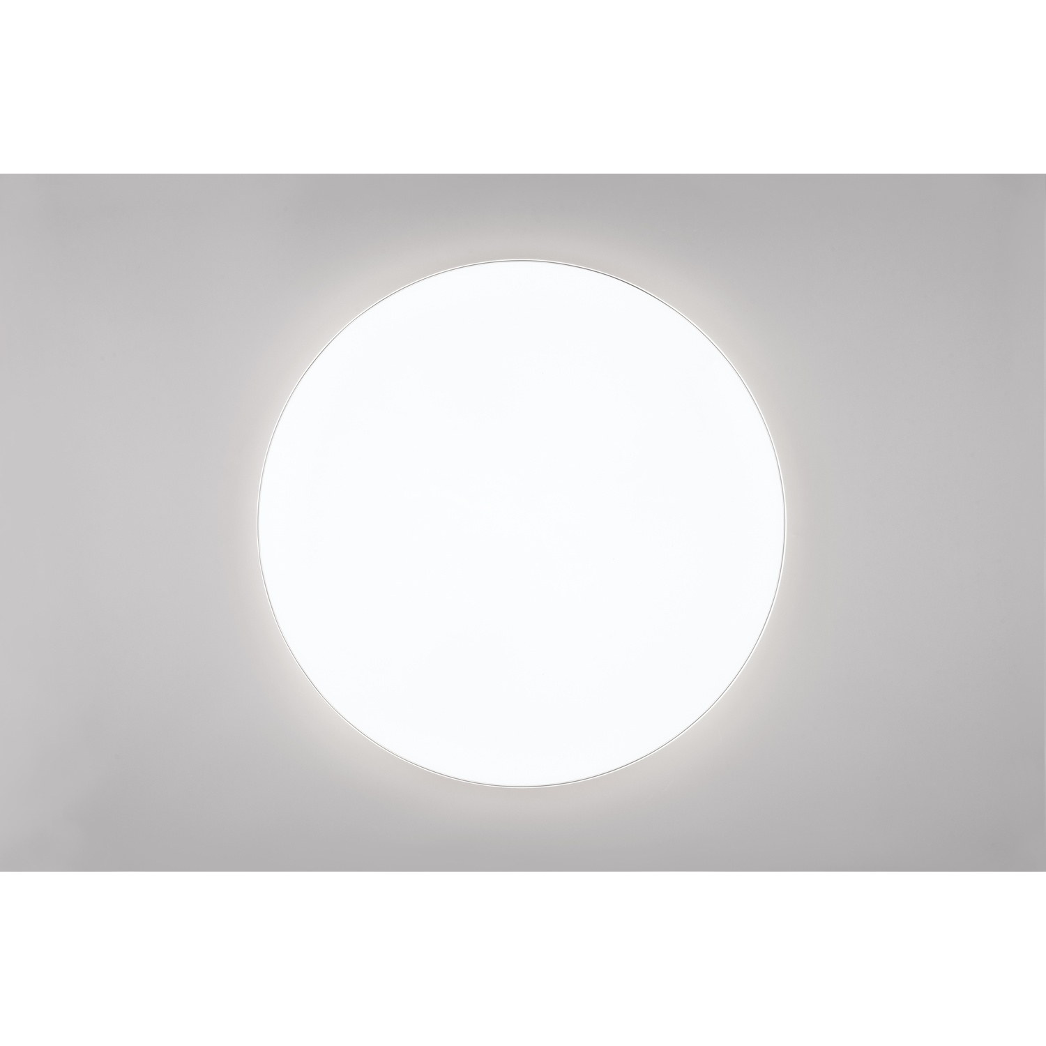 Un grande cerchio bianco e luminoso davanti a un muro grigio.