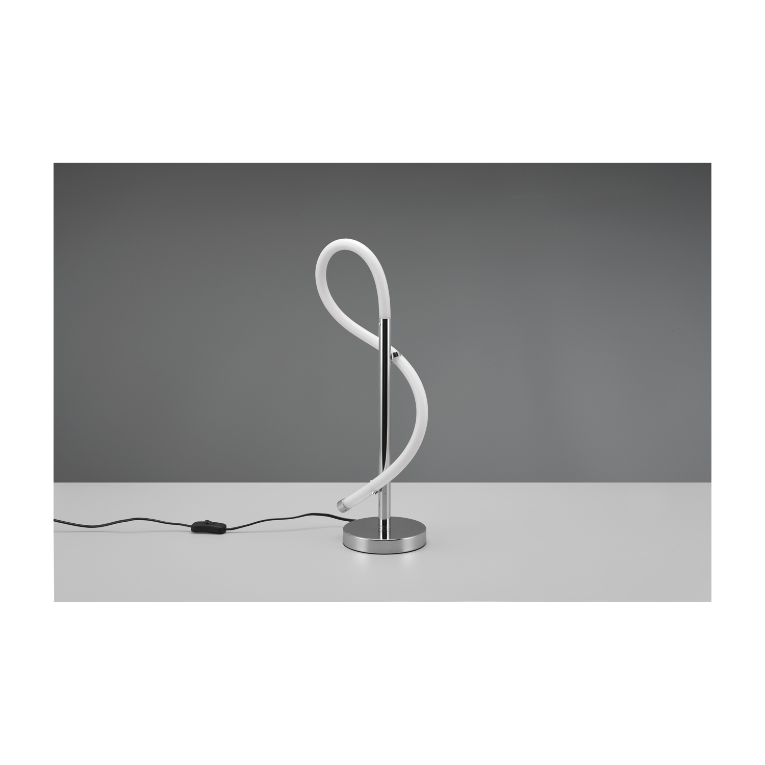 Una lampada da tavolo moderna bianca e argento con un design curvo, su una superficie bianca, sfondo grigio.