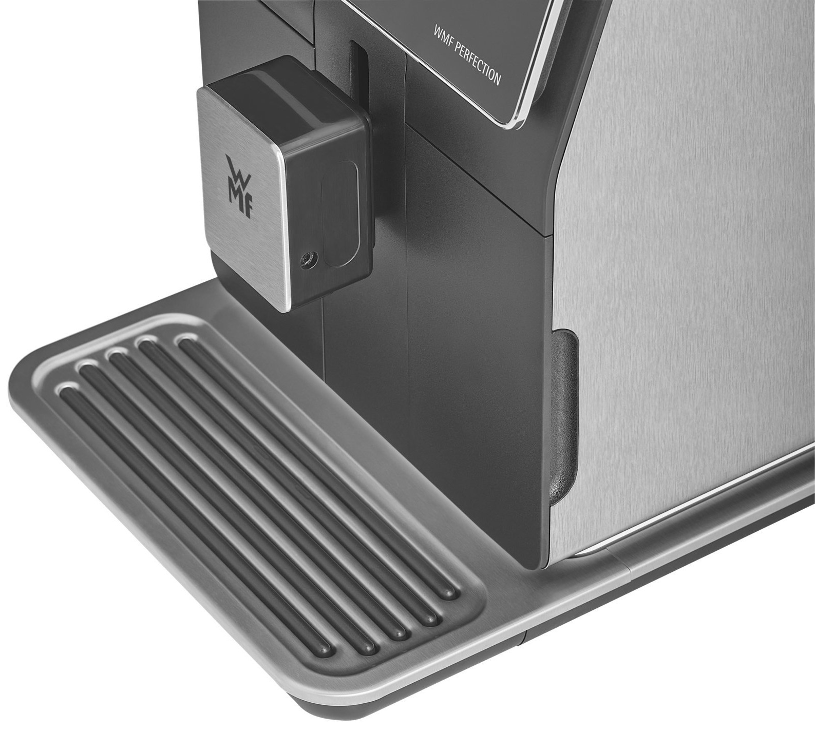 Zbliżenie na przód ekspresu do kawy. Pokazuje tackę ociekową i logo WMF.