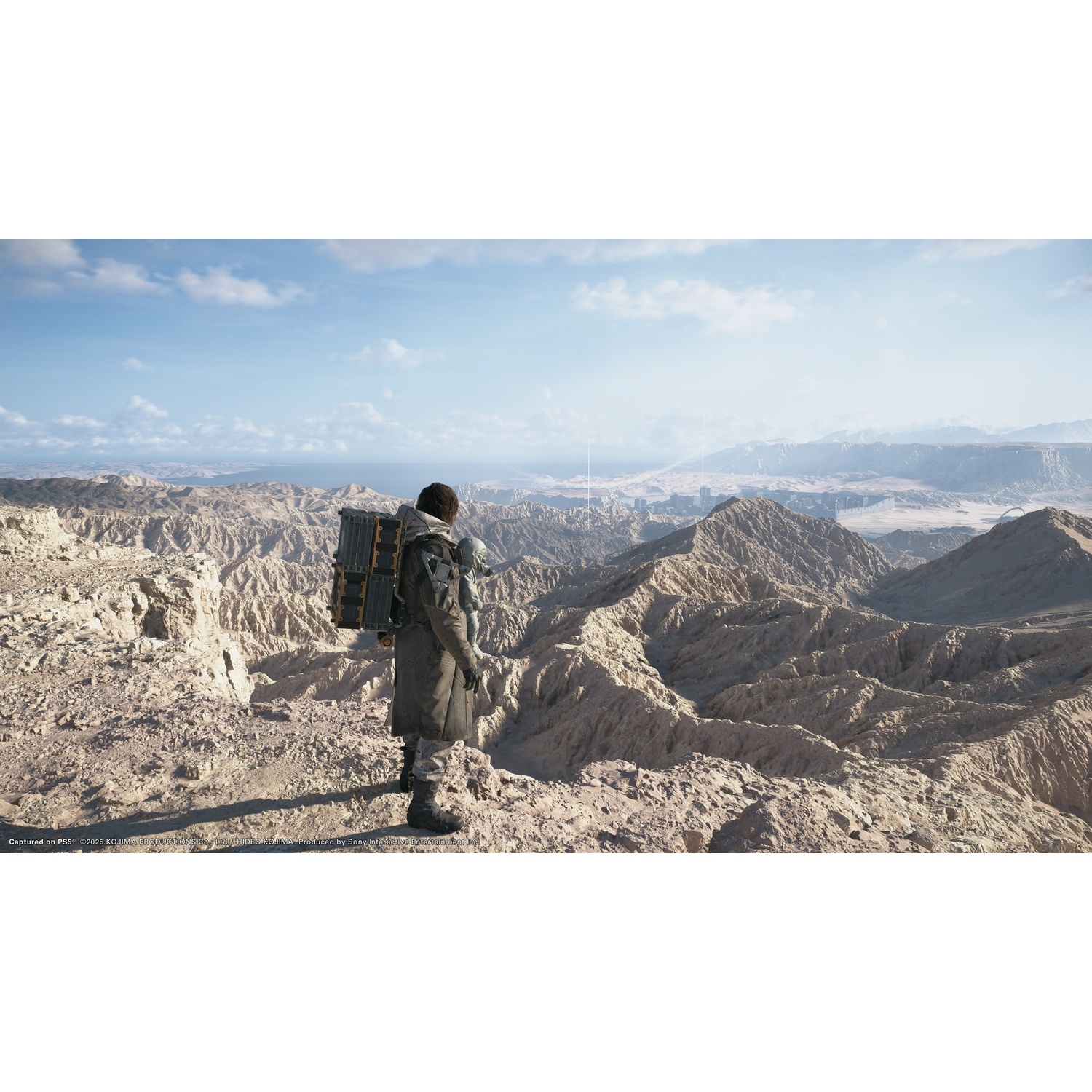 Una persona in piedi su una montagna rocciosa, che guarda un vasto paesaggio.