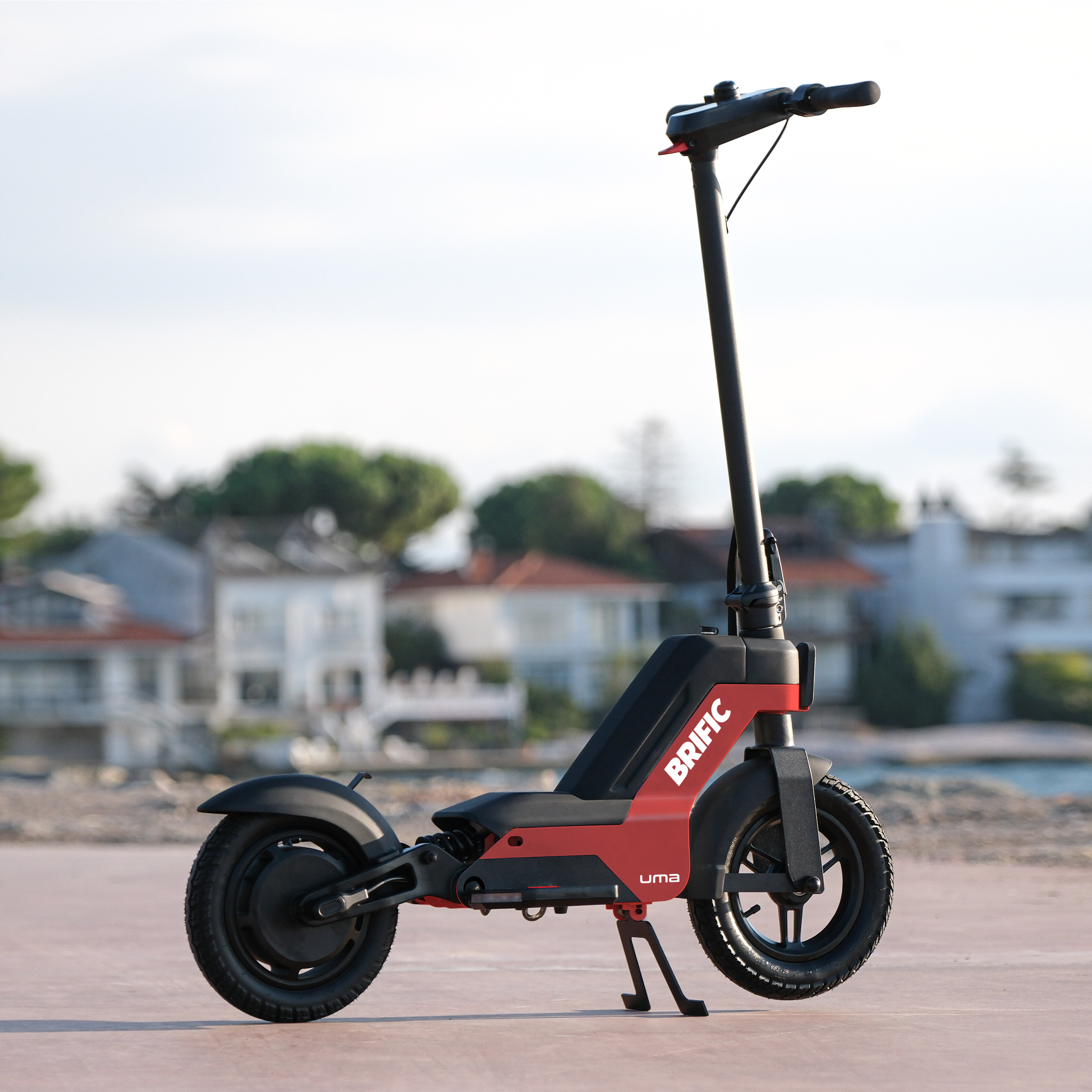 Beton bir yüzeyde kırmızı ve siyah bir elektrikli scooter.