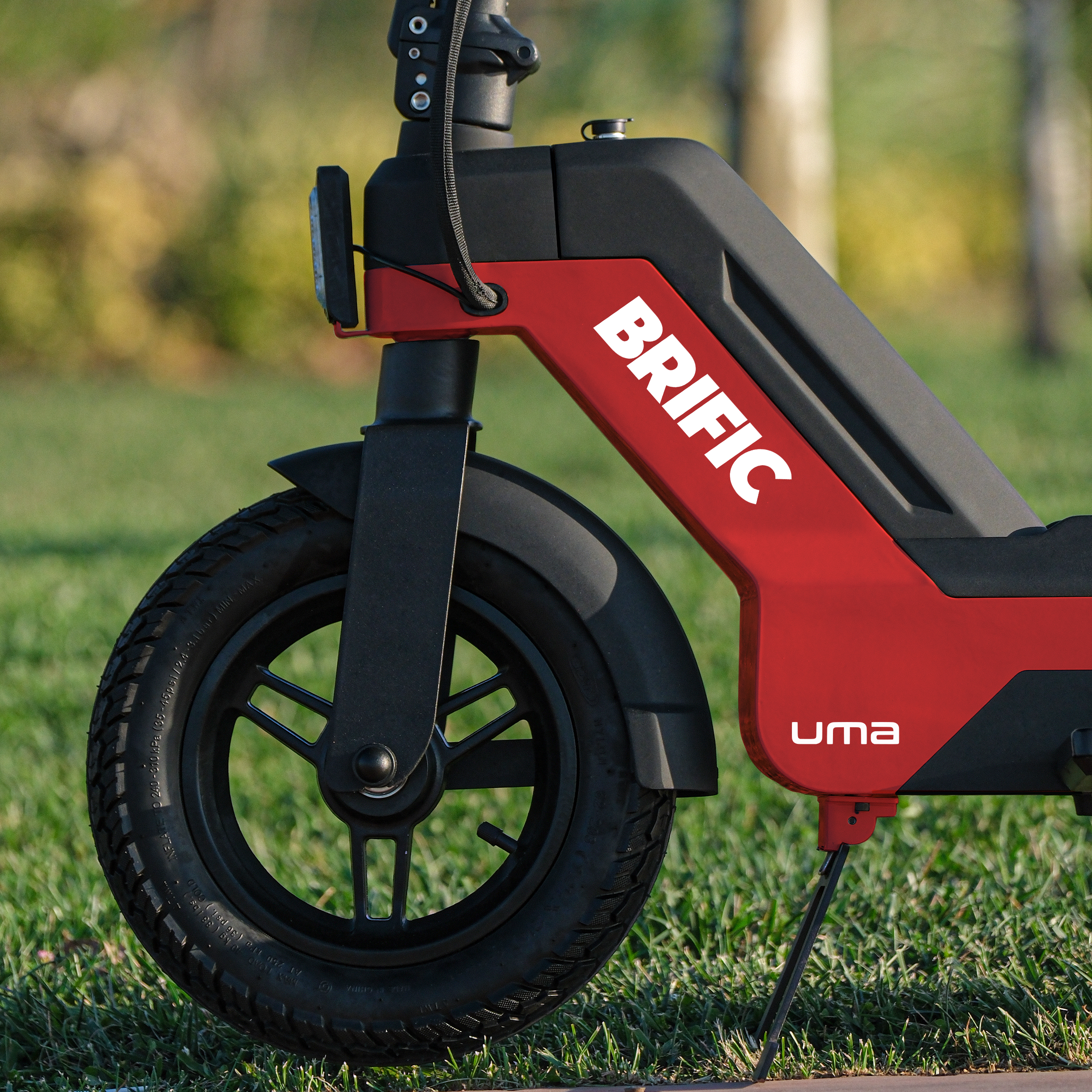 Kırmızı ve siyah bir scooter'ın ön tekerleği, 'BRIFIC' markası görünür.