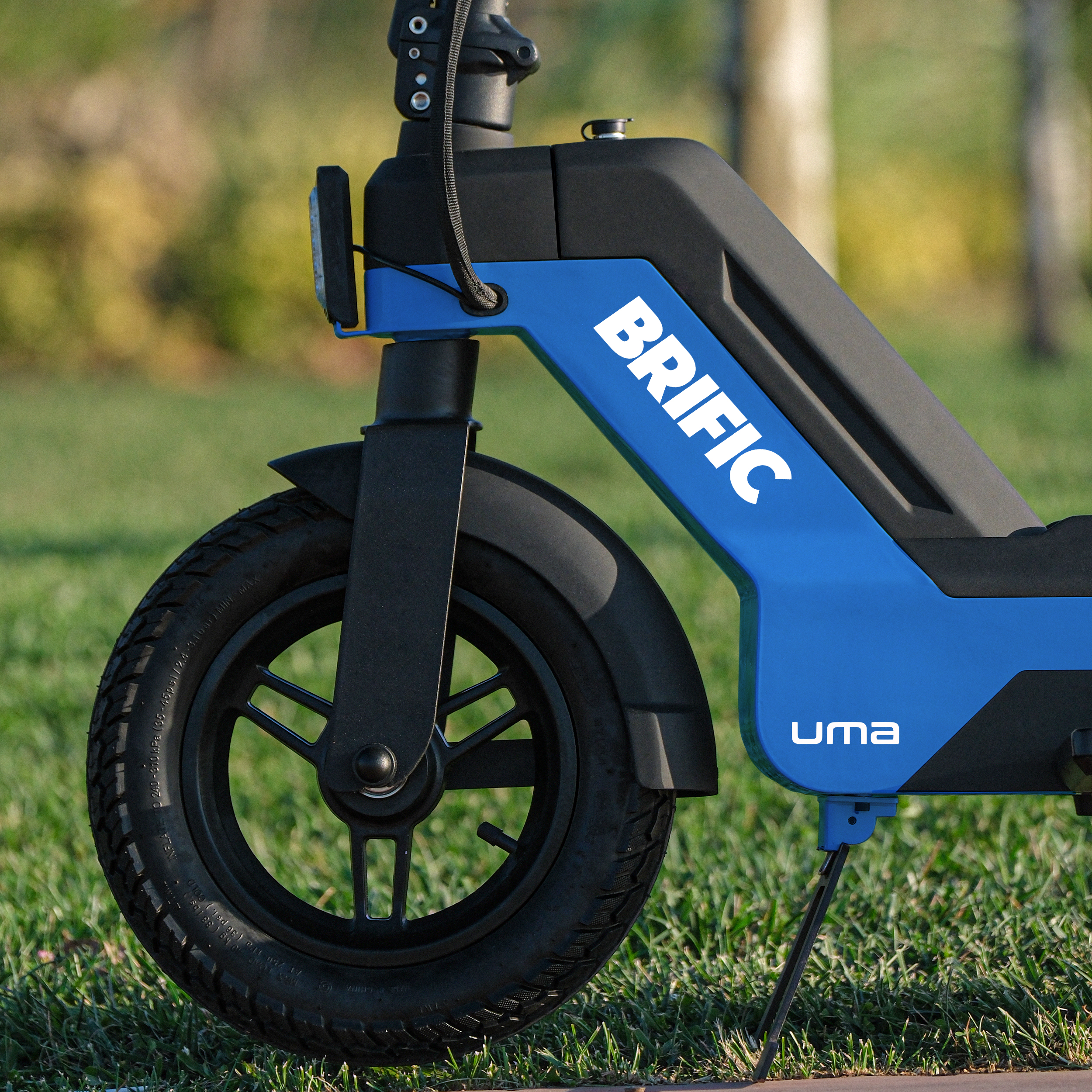 Üzerinde 'BRIFIC' marka adı bulunan bir scooter tekerleğinin yakın çekim görüntüsü.