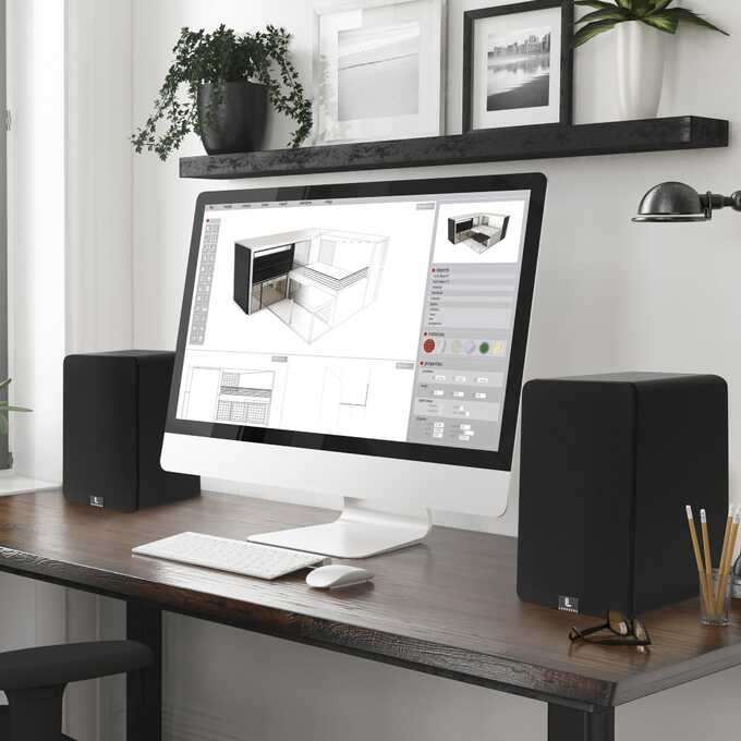 Komputer stacjonarny z komputerem wyświetlającym plany projektowe kuchni i dwoma głośnikami.
