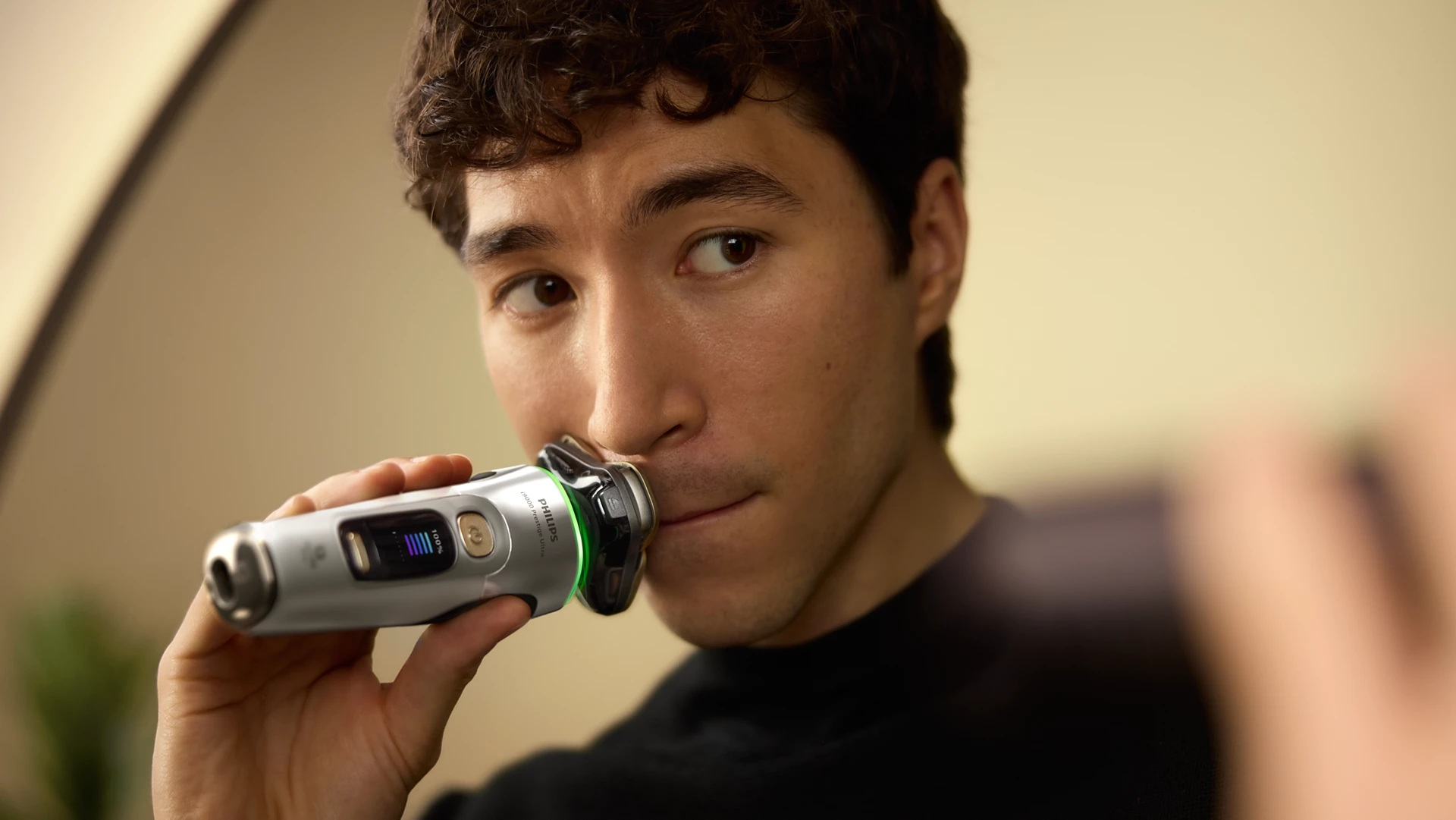 Mężczyzna golący się elektryczną golarką Philips.