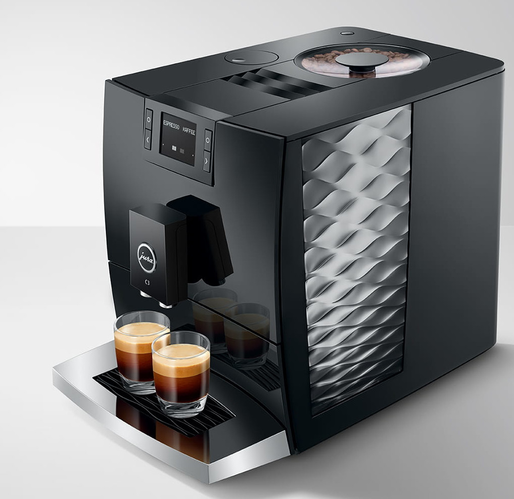 Czarny ekspres do espresso z dwoma gotowymi espresso. Widoczne ziarna kawy.