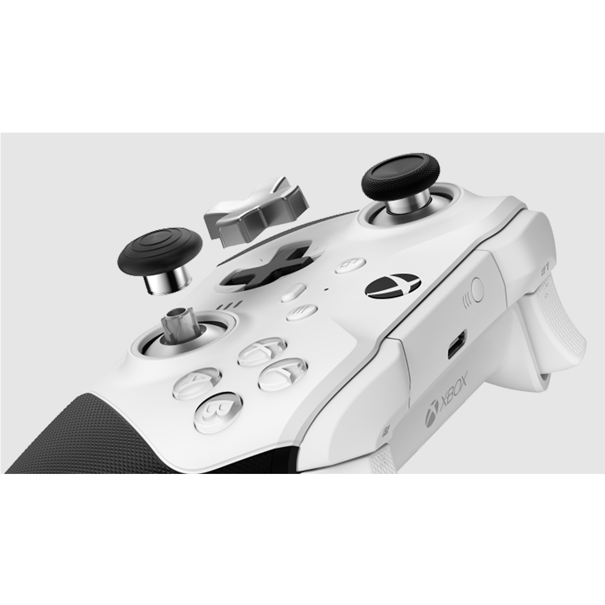 Controlador Xbox blanco con botones y joysticks retirados. El controlador está parcialmente desmontado.