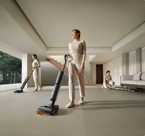 Modernes Interieur mit drei Frauen, die einen Bodenreiniger benutzen. Eine steht, zwei putzen den Boden.