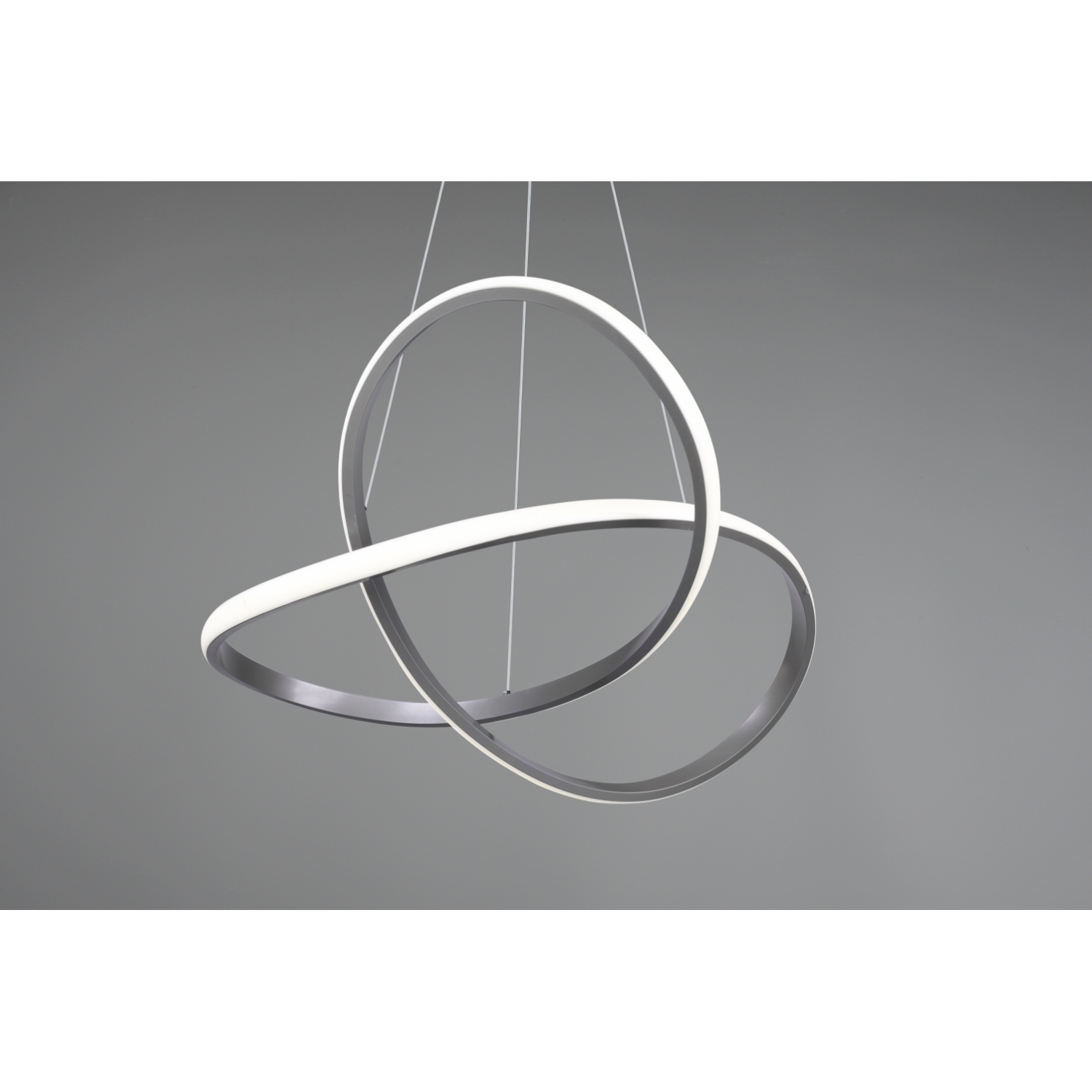 Lampada da soffitto moderna con due anelli intersecanti, che emettono una luce bianca, sospesa su uno sfondo grigio.