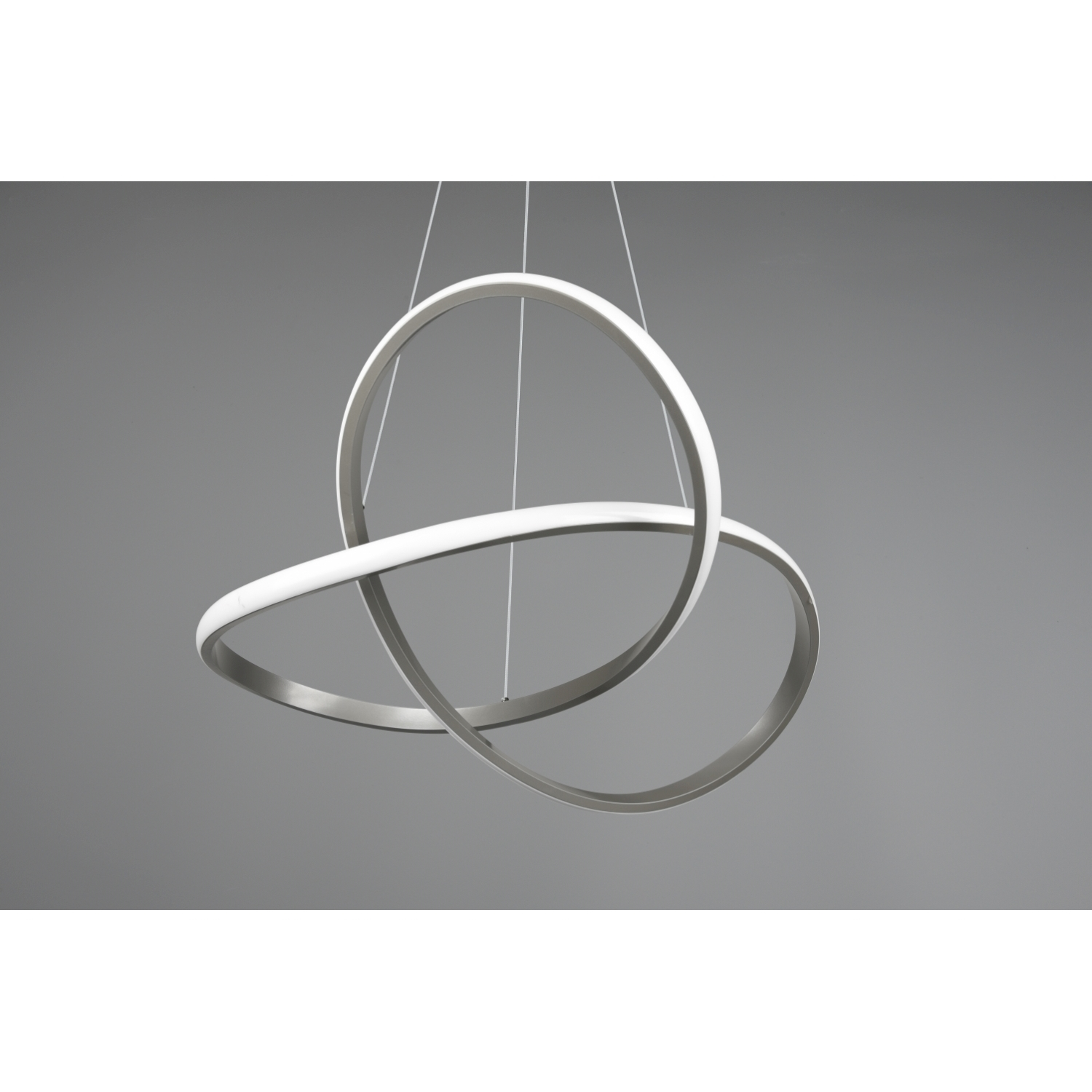 Un moderno apparecchio di illuminazione argentato è appeso al soffitto. L'apparecchio ha tre bande circolari intersecanti.