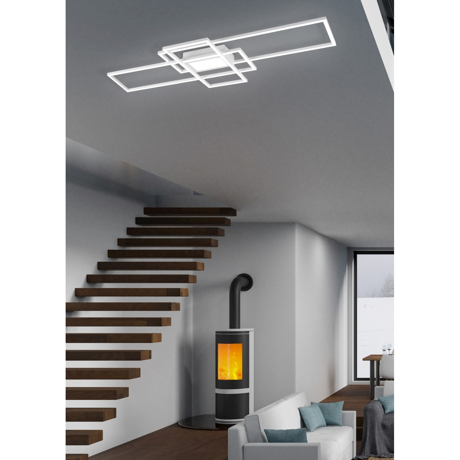 Un soggiorno con scala, camino e divano bianco. Un moderno apparecchio di illuminazione è sul soffitto.