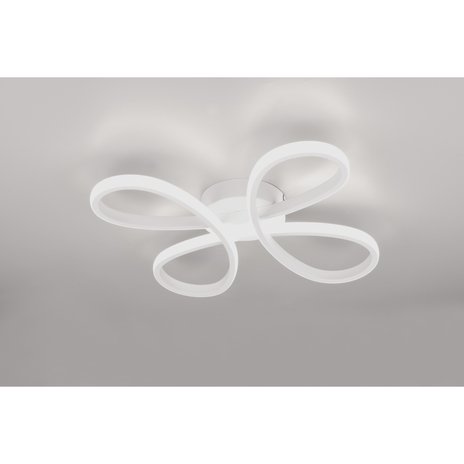Un apparecchio di illuminazione a soffitto bianco con un design a forma di fiore. Ha quattro bracci curvi ad anello.