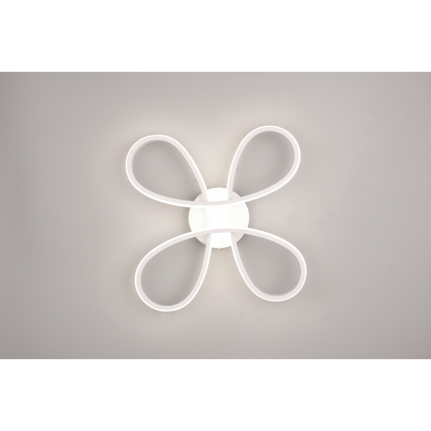 Un apparecchio di illuminazione a soffitto bianco con un design a quattro anelli, illuminato contro un soffitto bianco.