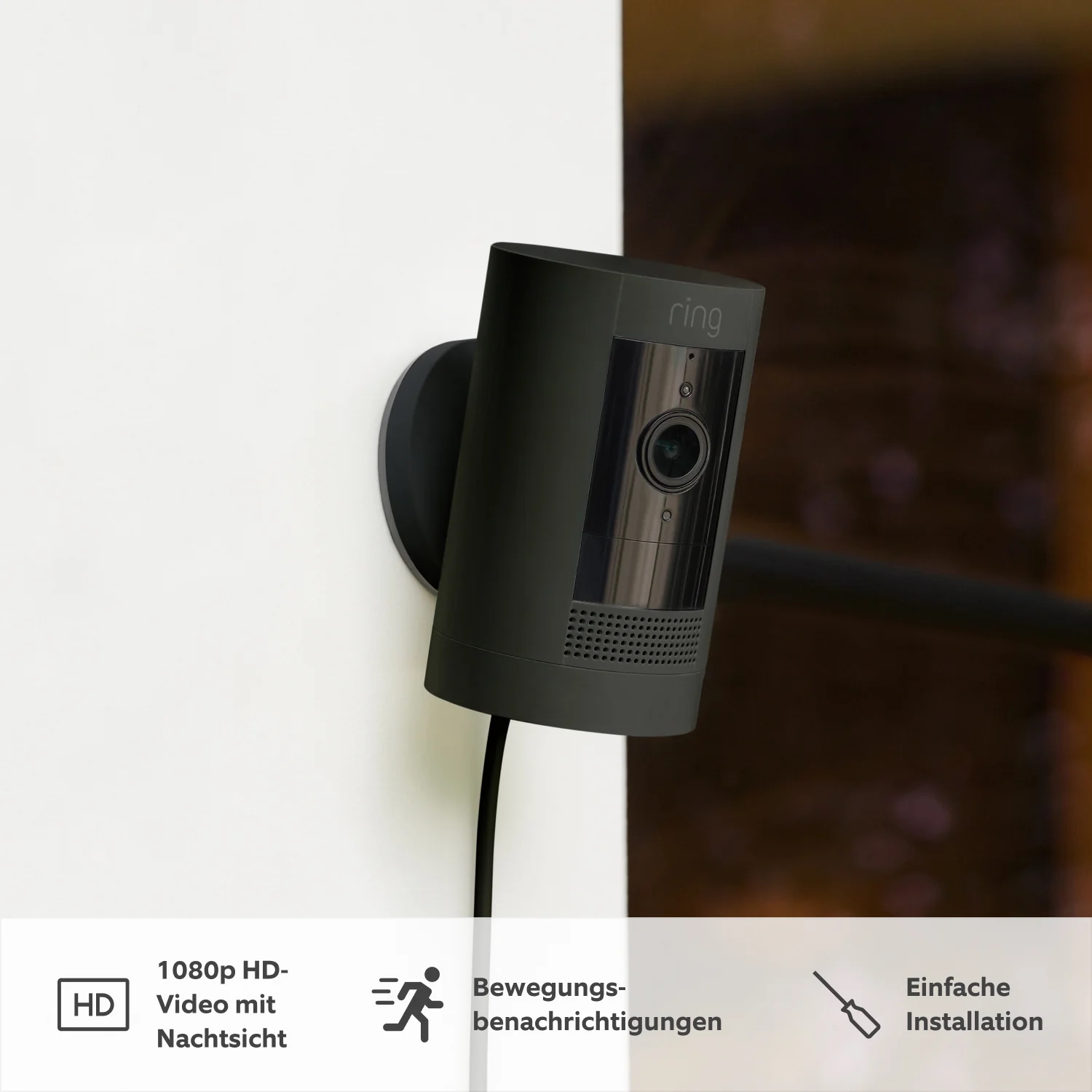 Eine Ring Stick Up Cam Pro Kamera auf einem Regal, andere Gegenstände und Text.