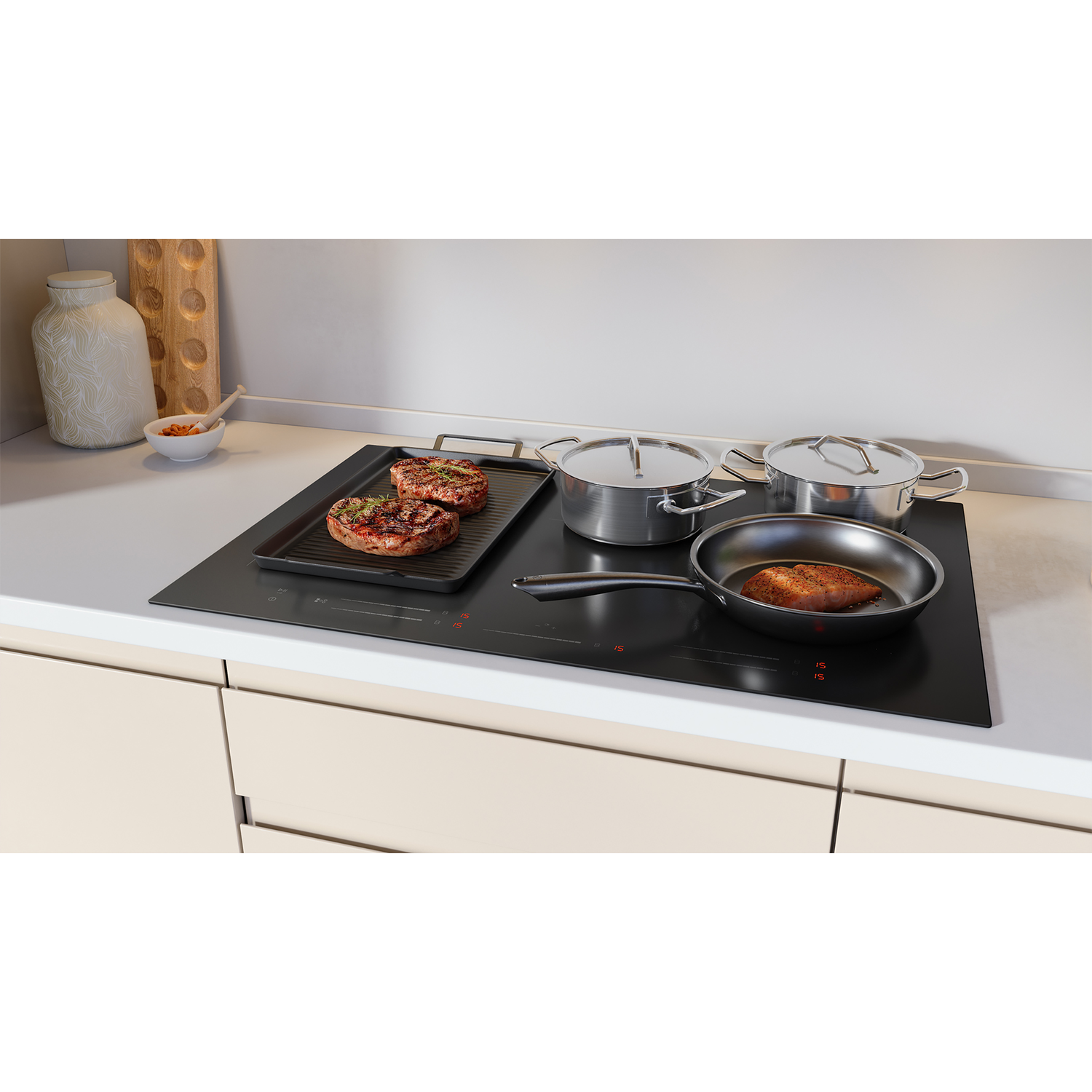 A black cooktop with food on it, and pots and pans. The cooktop is on a counter.