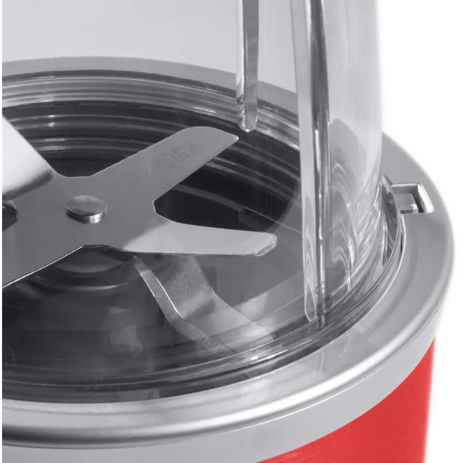 Nahaufnahme einer Mixer-Klinge in einem roten Mixer. Die Klingen sind metallisch und scharf.