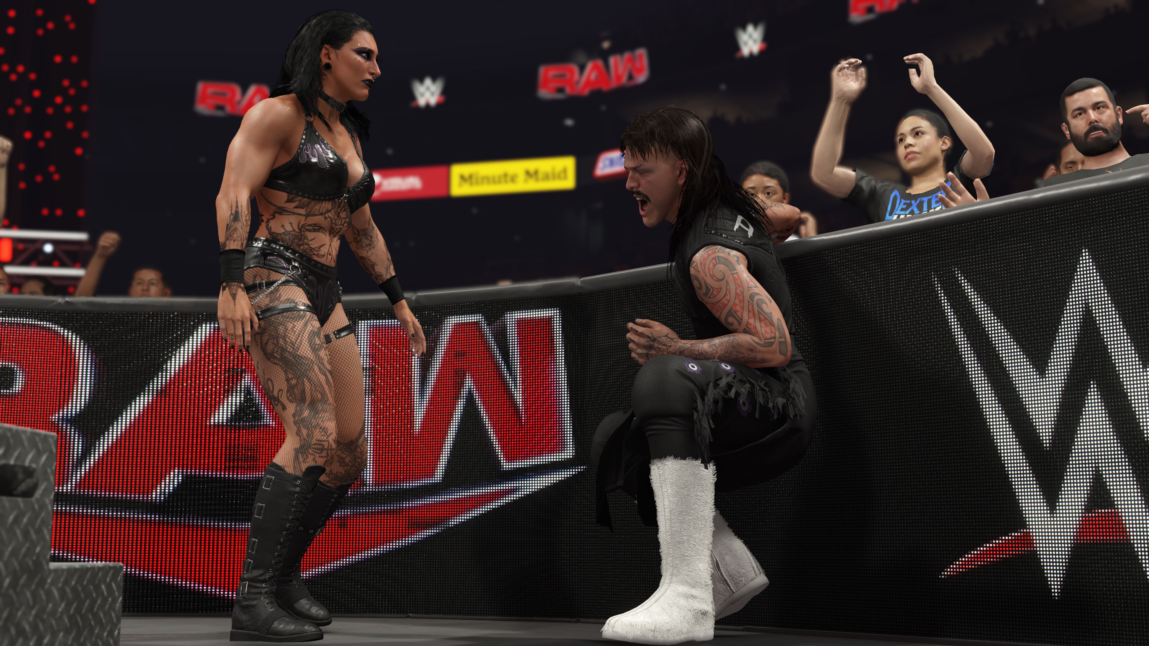 WWE güreş maçı, ringde iki güreşçiyle. Biri diz çöküyor, diğeri ayakta duruyor.