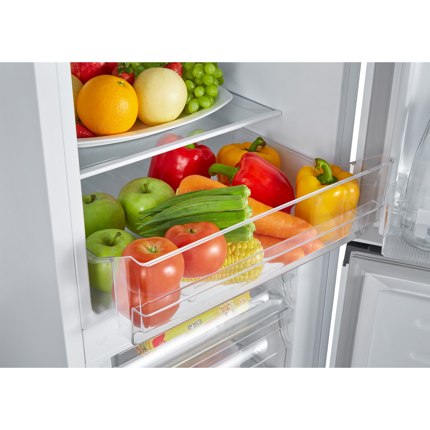A refrigerator interior filled with fruits and vegetables in clear drawers. A variety of fresh produce is visible.