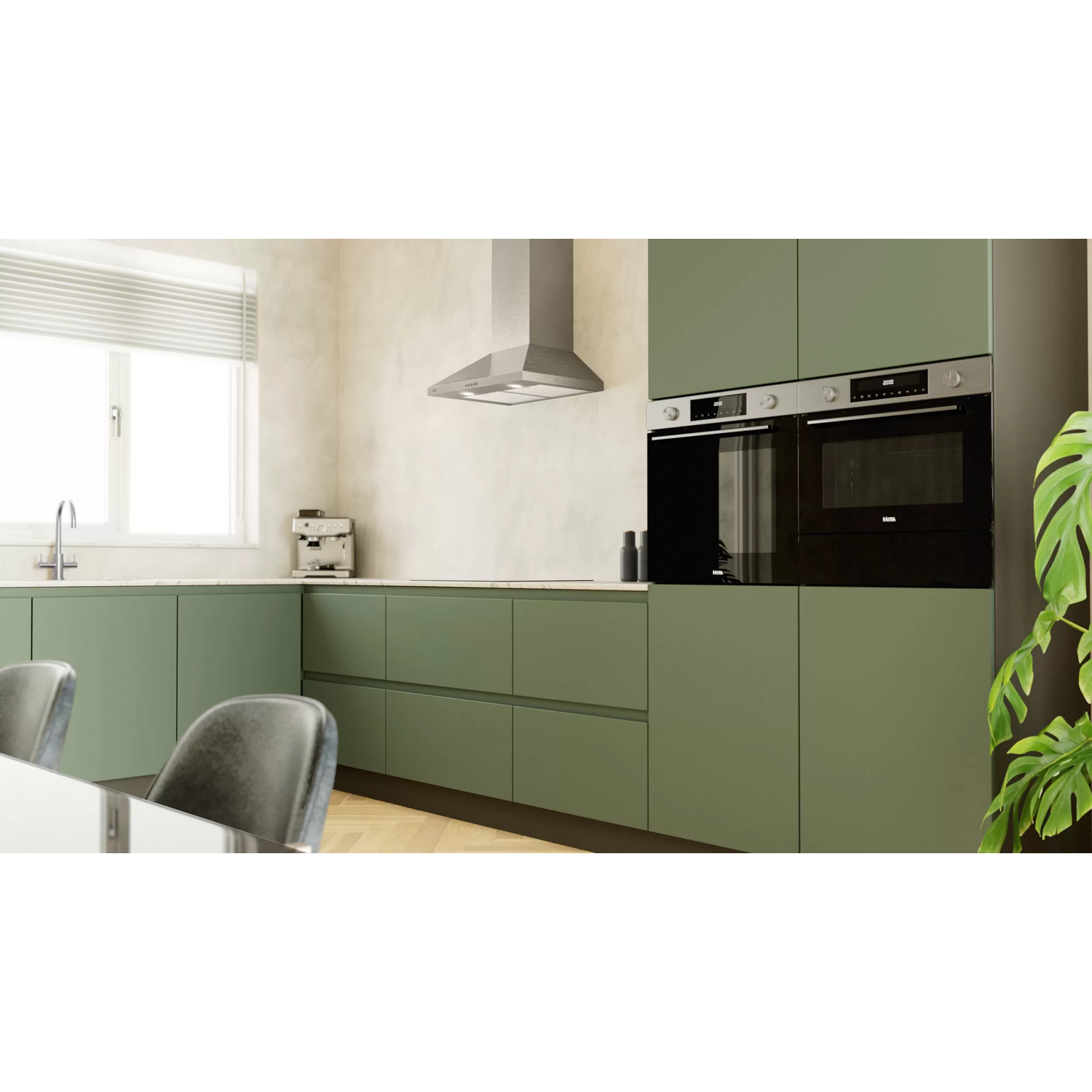 A green kitchen with modern appliances. Includes cabinets, ovens, a range hood, and a window.