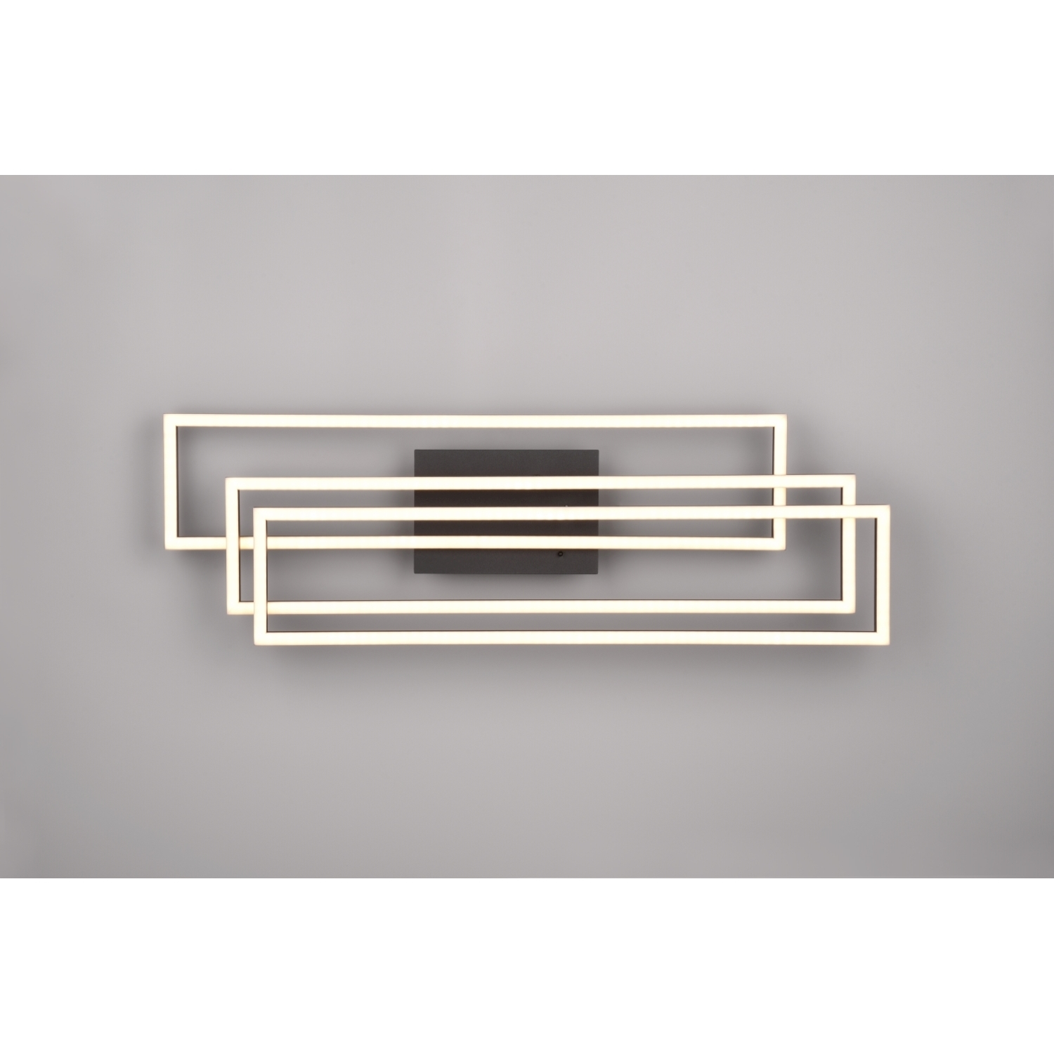 Un apparecchio di illuminazione da parete in stile moderno con tre telai rettangolari interconnessi con illuminazione brillante.
