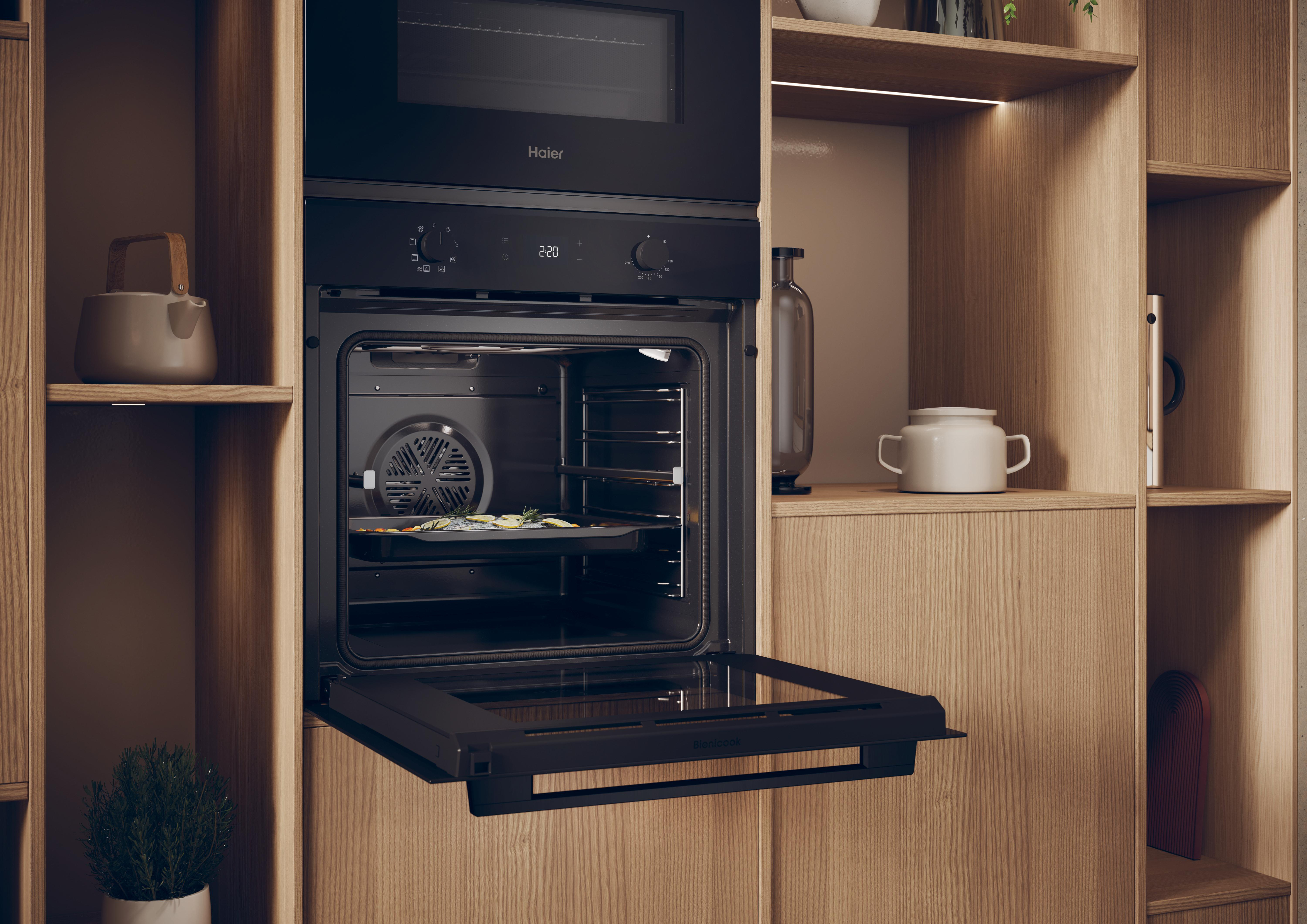 Ein offener Einbau-Backofen mit einem Blech darin. Er ist schwarz und steht in einem Holzschrank.