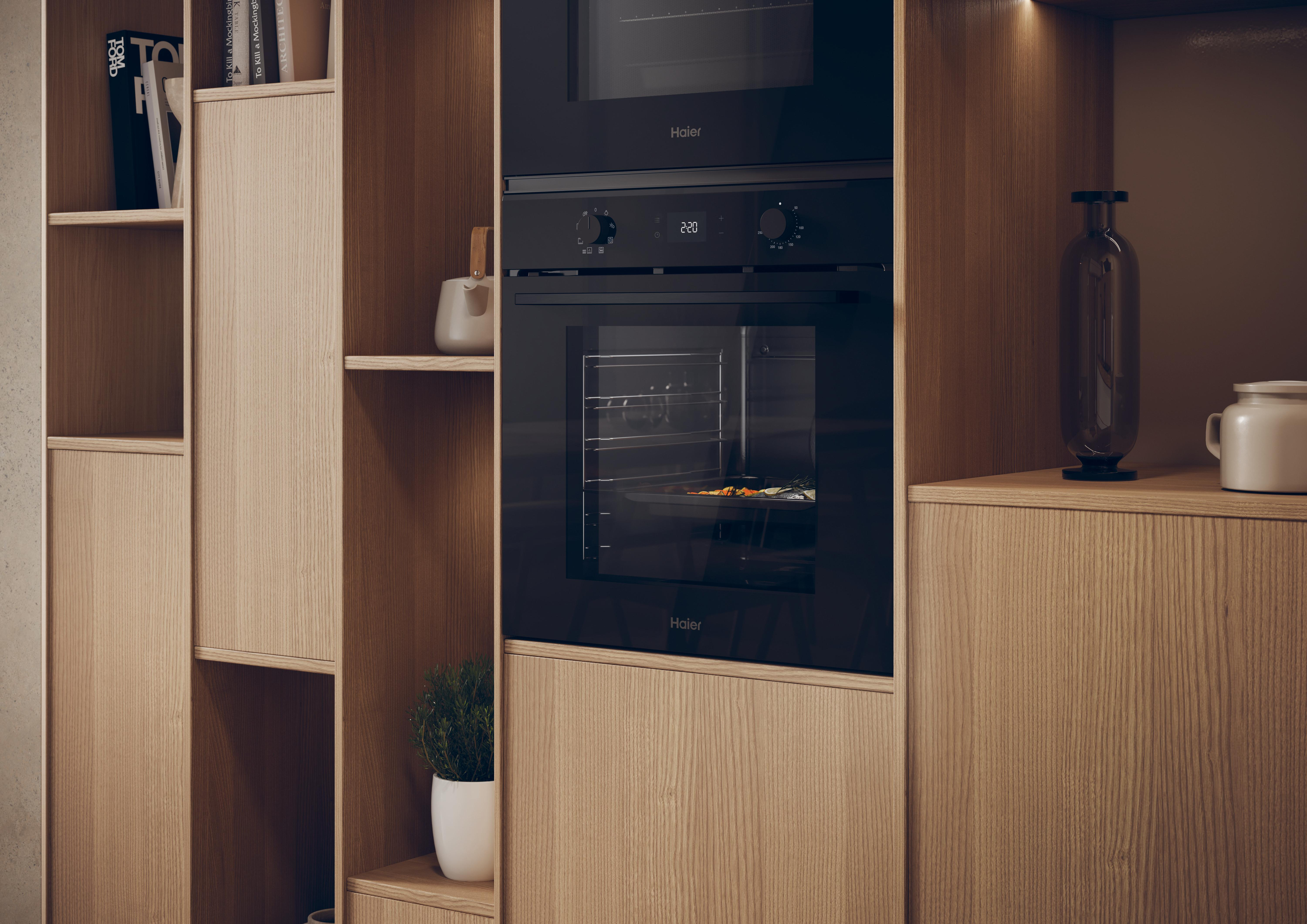 Eine Küche mit Holzschränken und einem eingebauten schwarzen Backofen. Eine Pflanze und Flaschen auf den Regalen.