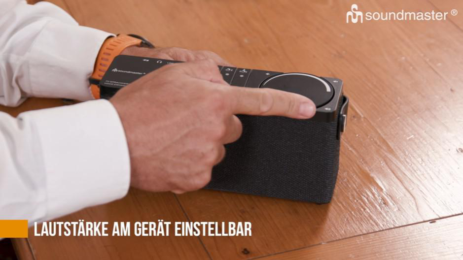 Hände einer Person, die einen Lautsprecher halten.