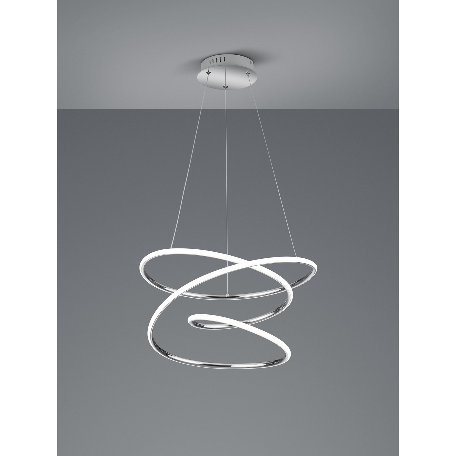 Un lampadario moderno con tre elementi circolari illuminati sospesi su uno sfondo grigio.