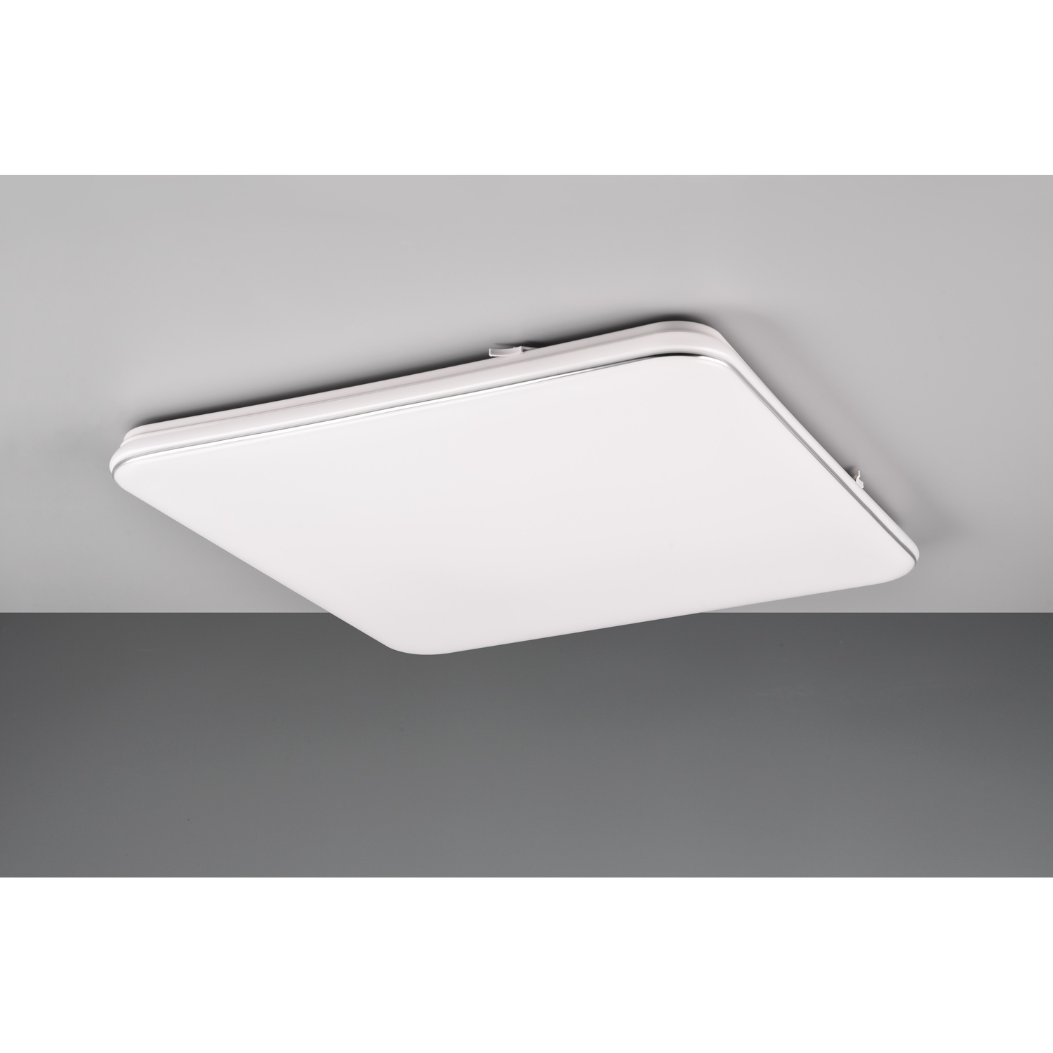 Apparecchio di illuminazione a soffitto quadrato bianco su sfondo grigio e bianco.