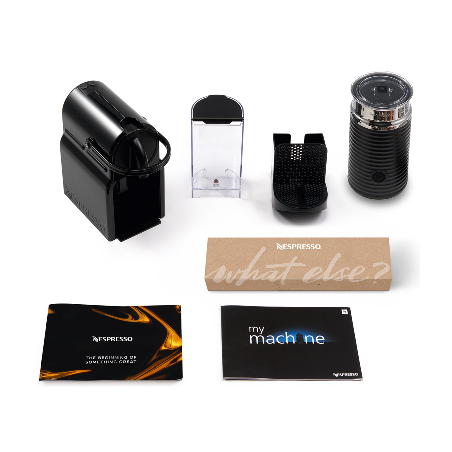 Macchina da caffè, accessori e una scatola su bianco.
