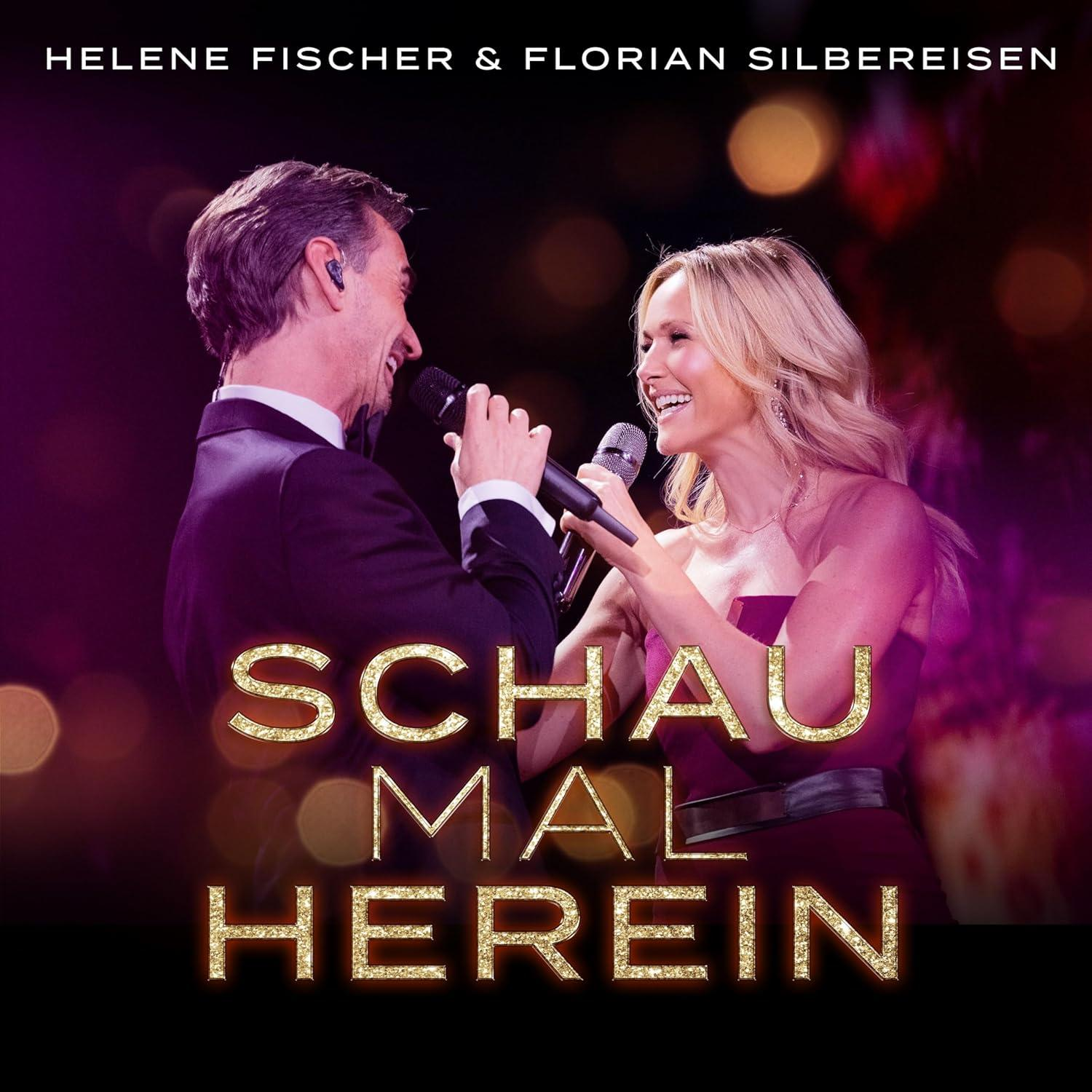 Albumcover mit zwei Personen, die auf der Bühne singen, mit goldenem Text.