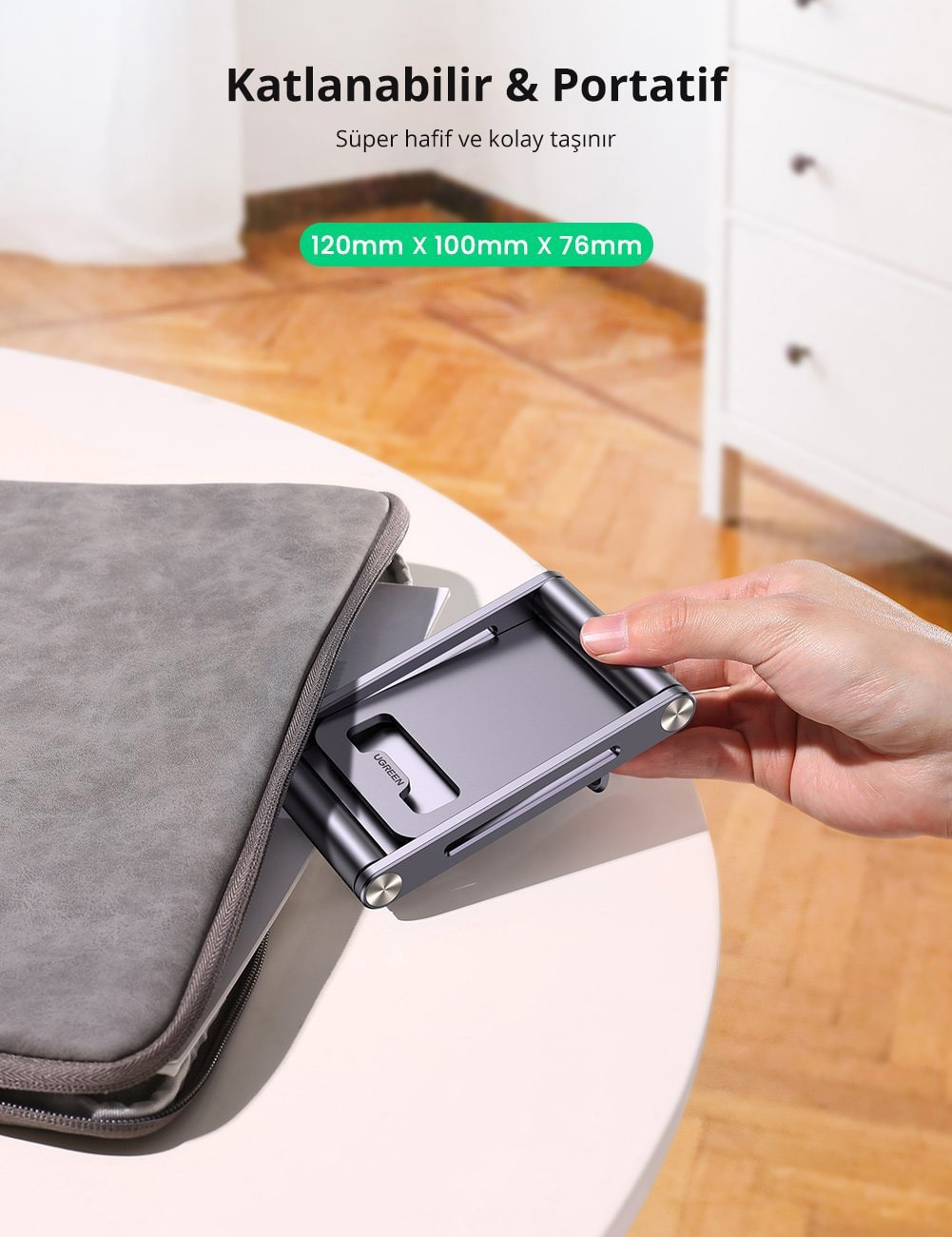 Gri bir çantada katlanabilir tablet standı. Stand gümüş ve gri renktedir, beyaz bir arka plan üzerinde.