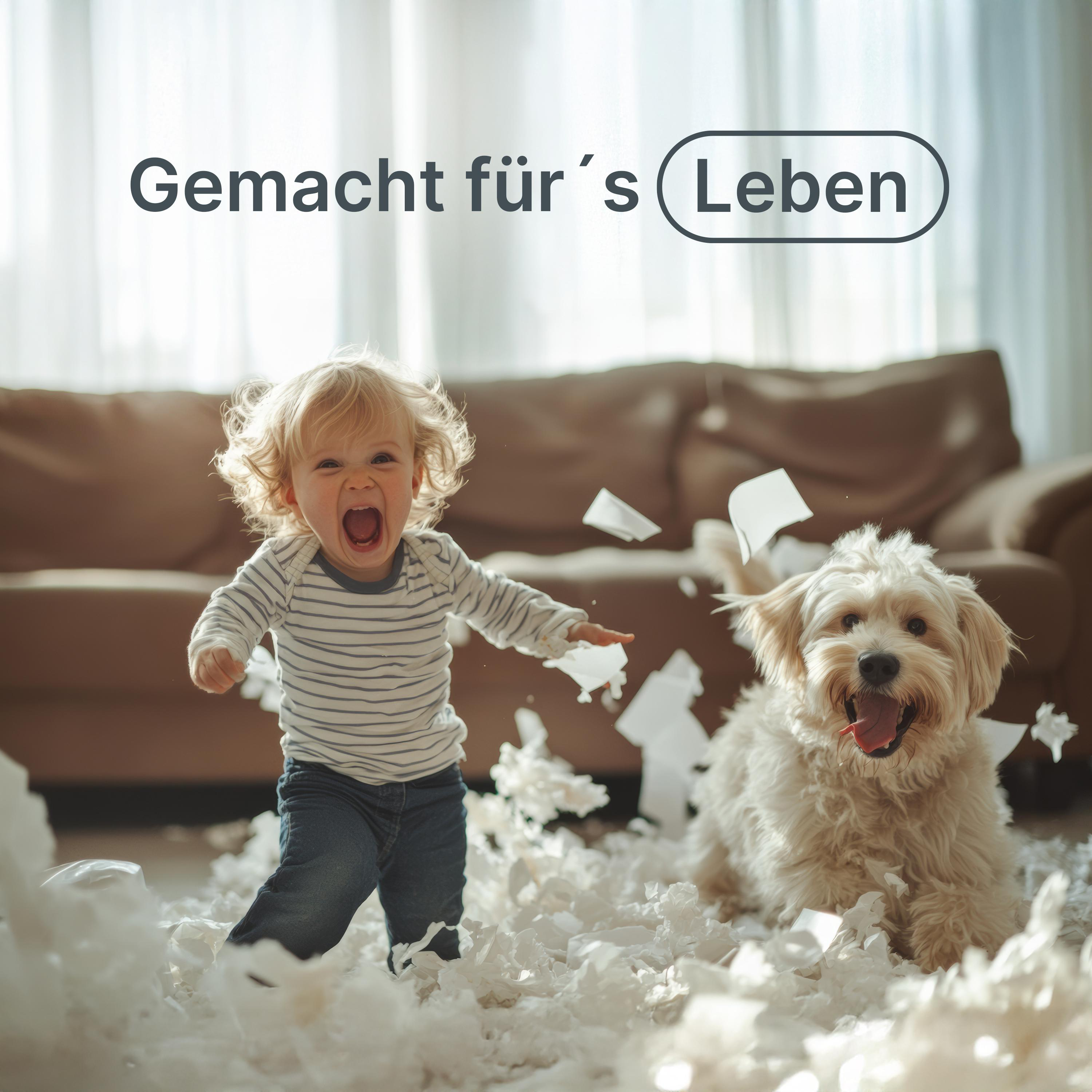 Kind und Hund im Wohnzimmer. Papier verstreut. Textüberlagerung 'Gemacht für's Leben'.