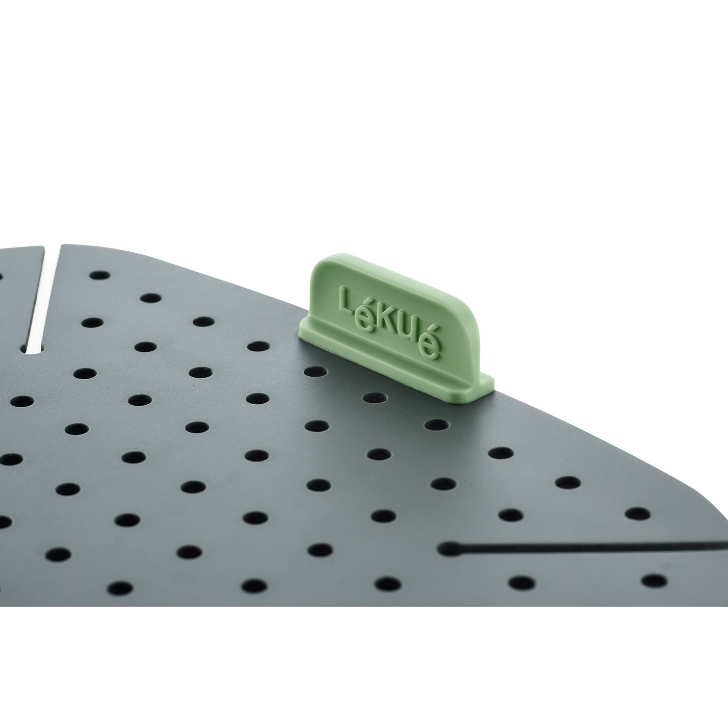 A green plastic food steamer with a gray surface and a green handle.