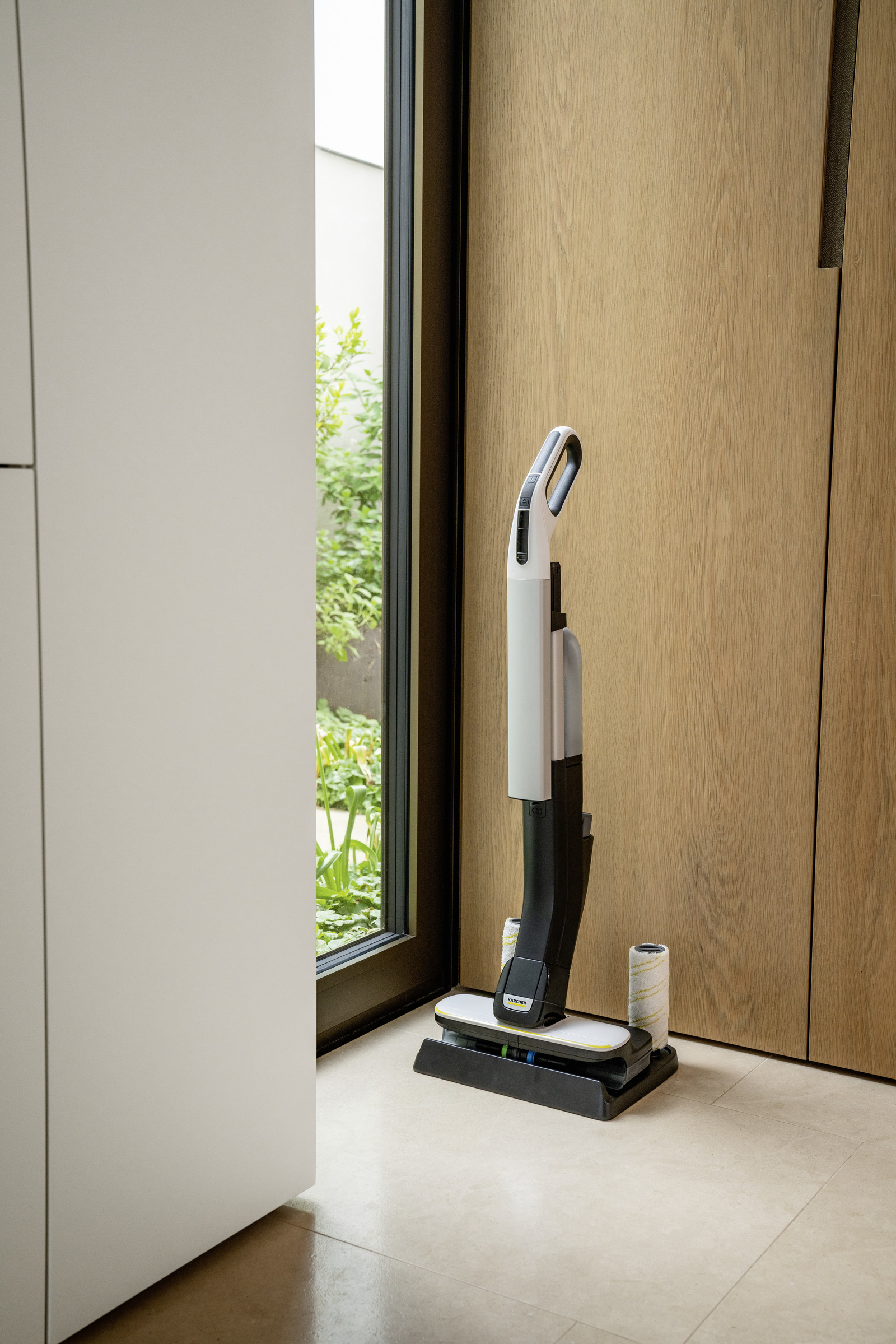 Biało-szary odkurzacz Kärcher stojący obok drzwi.