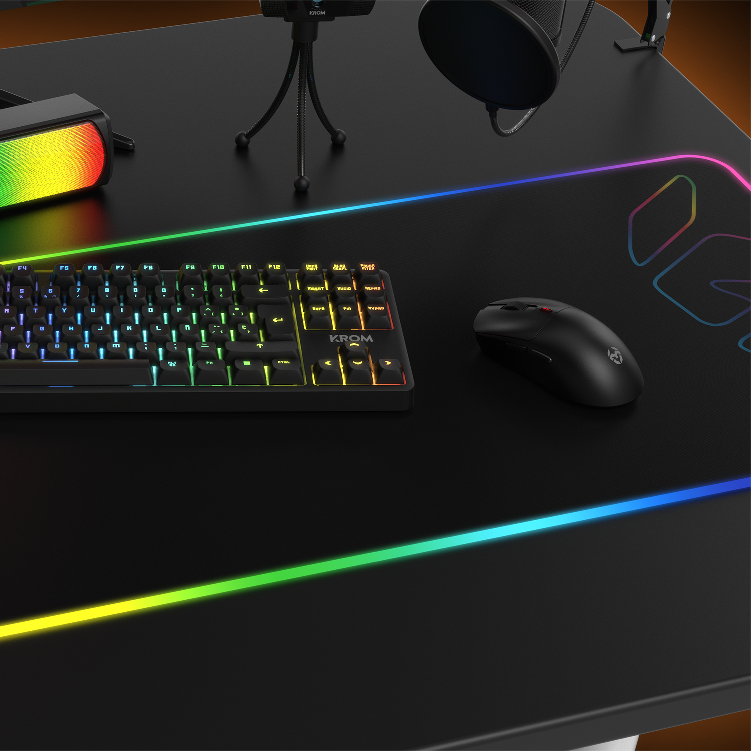 Teclado, ratón y micrófono sobre un escritorio negro.